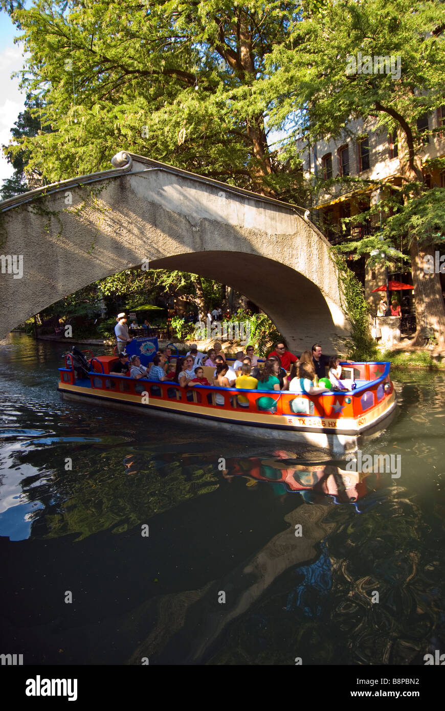San Antonio River Walk über Riverwalk Tourenboot mit Touristen unterquert gewölbte Brücke über die San Antonio River Stockfoto