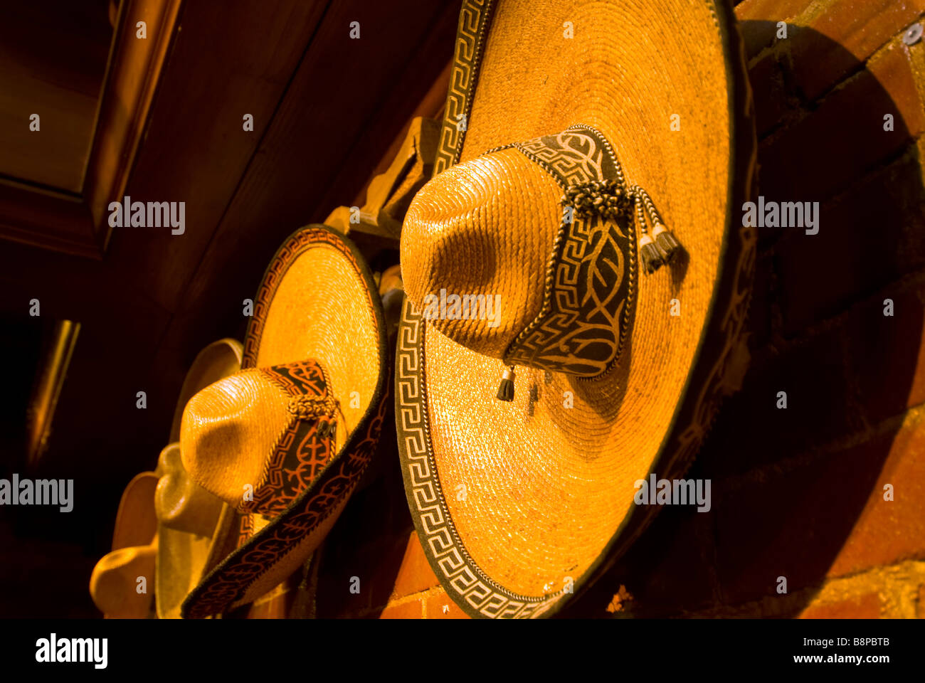 Mexikanische Sombreros drinnen an Wand hintereinander hängen Stockfoto