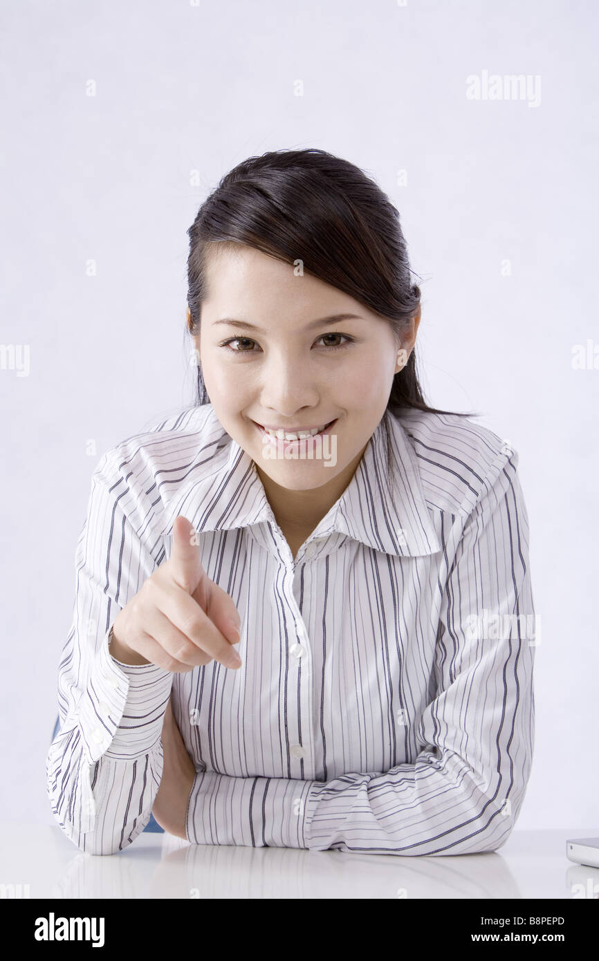 Junge Geschäftsfrau zeigt eine Richtung, Lächeln, Porträt Stockfoto