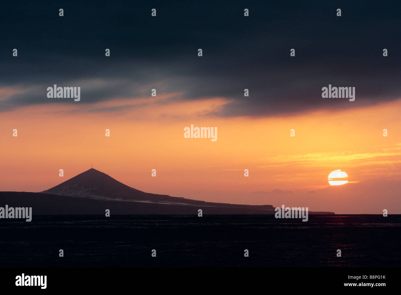 Sonnenuntergang von der Nordküste von Gran Canaria. Pico de Galdar vulkanischen Bergen in der Ferne. Stockfoto