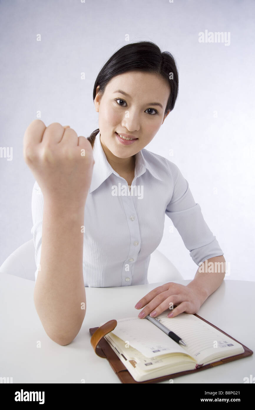 Junge Geschäftsfrau macht eine glückliche Geste mit Faust, Lächeln, Porträt Stockfoto