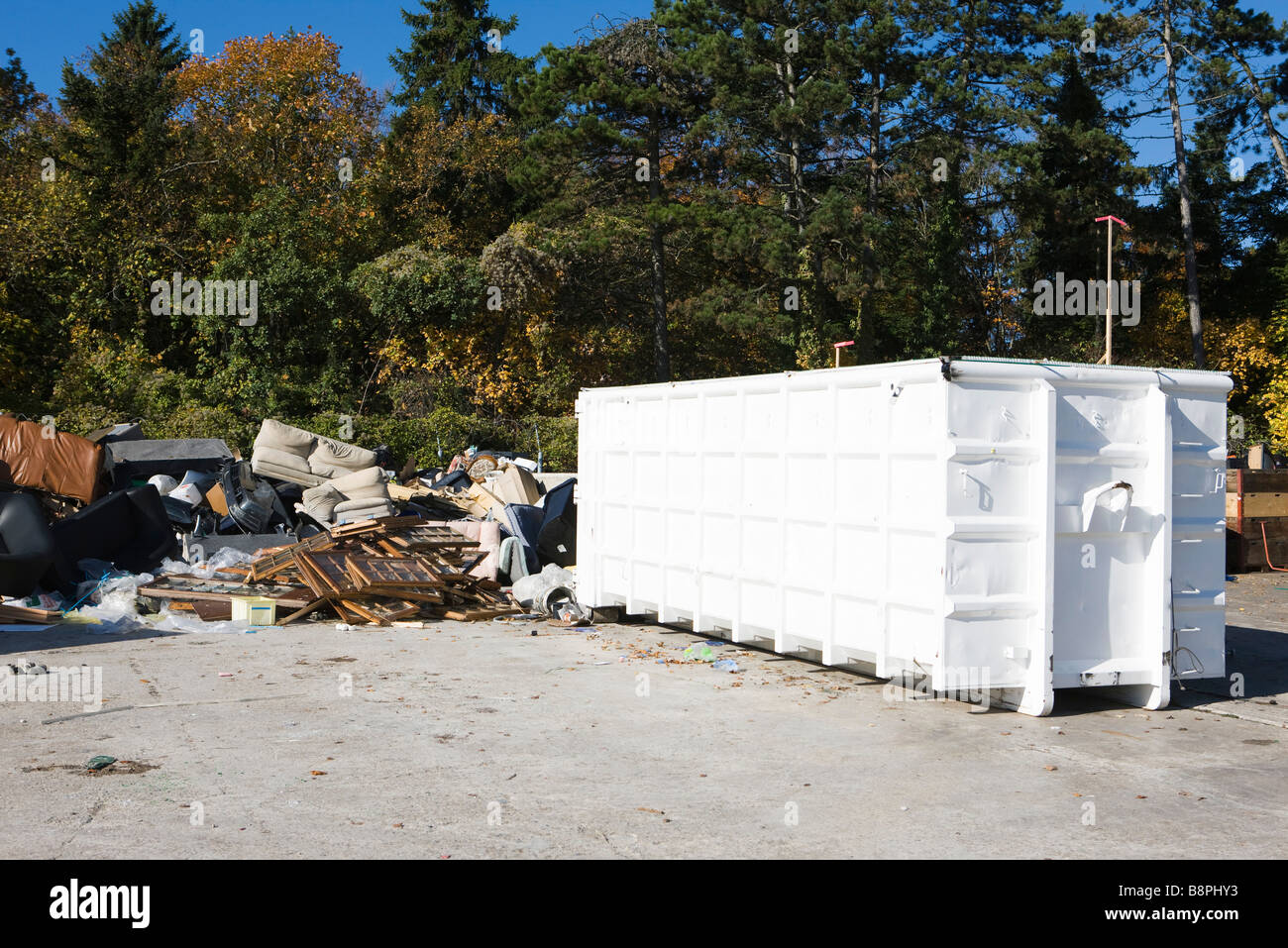 Junk-e-stapelten sich neben Müllcontainer Stockfoto