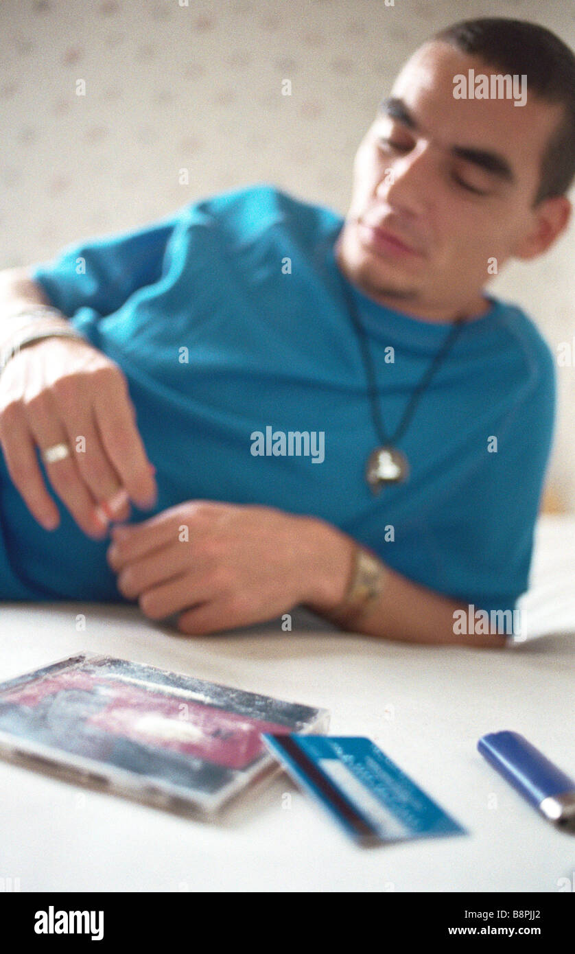 Junger Mann liegend im Bett Rauchen, Linie des Kokains auf cd-Hülle im Vordergrund Stockfoto