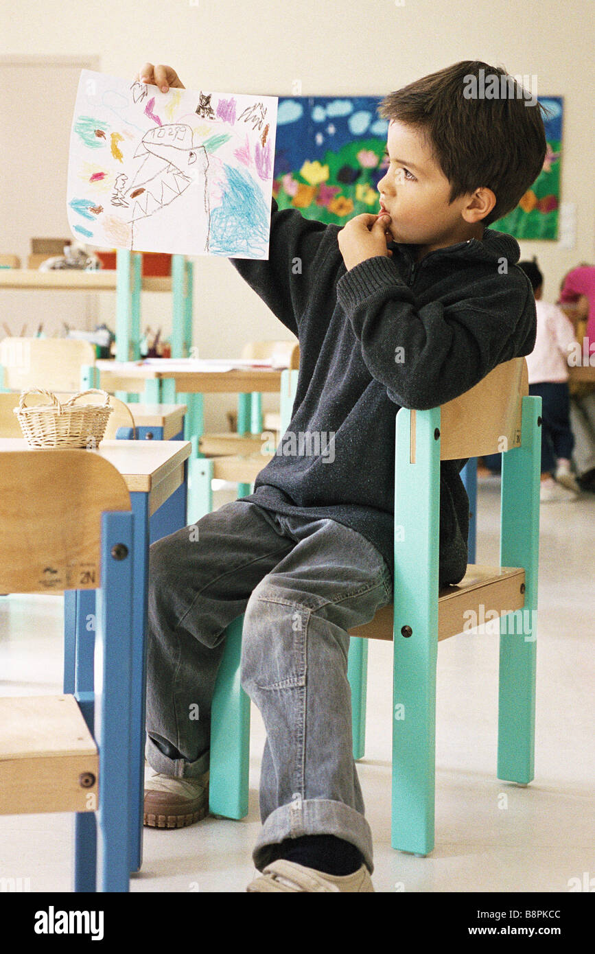 Junge hält Zeichnung im Klassenzimmer Stockfoto