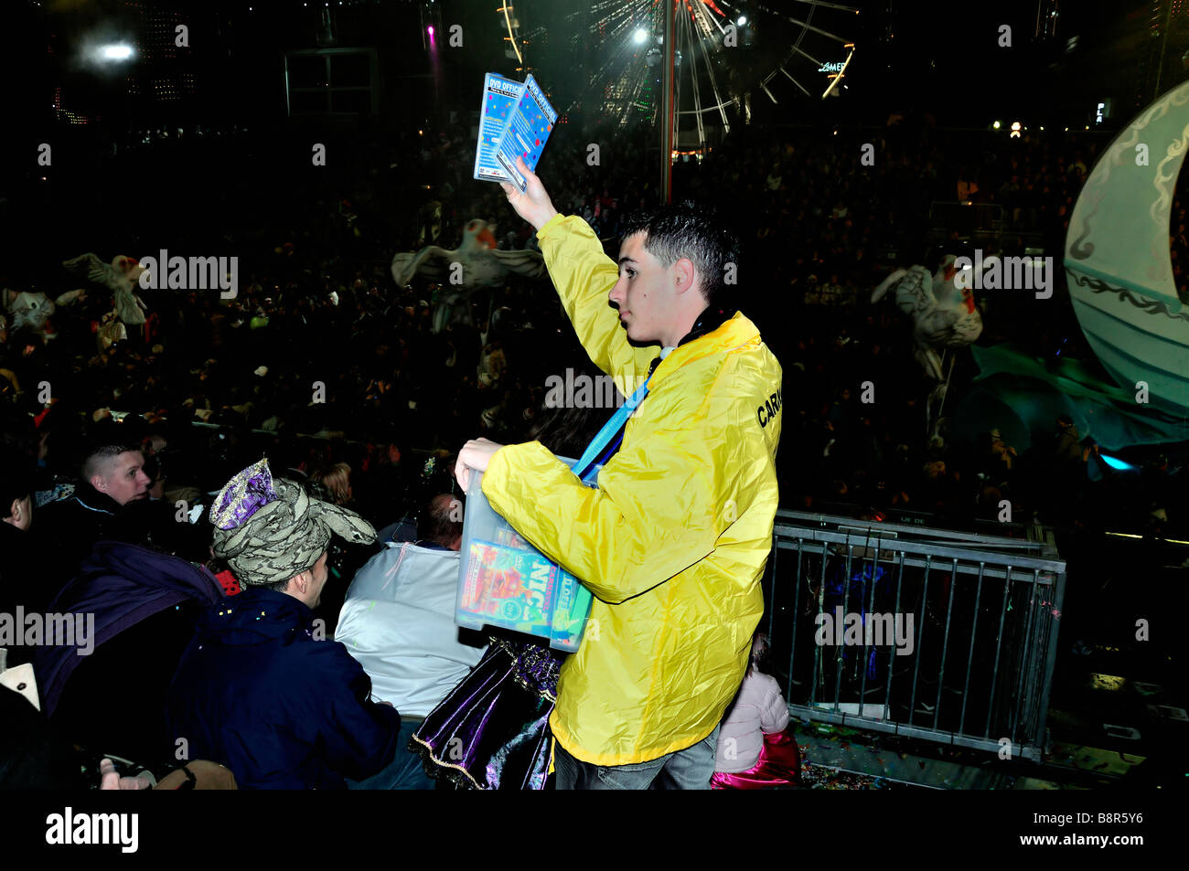 Nizza, Frankreich, Kostenlose öffentliche Veranstaltungen, Karnevalsparade, Männlich Teen Verkauf von Event-DVDs zu Menschenmengen arbeiten in der Nacht, Student Frankreich, Jugendliche Arbeitsplätze, prekär Stockfoto