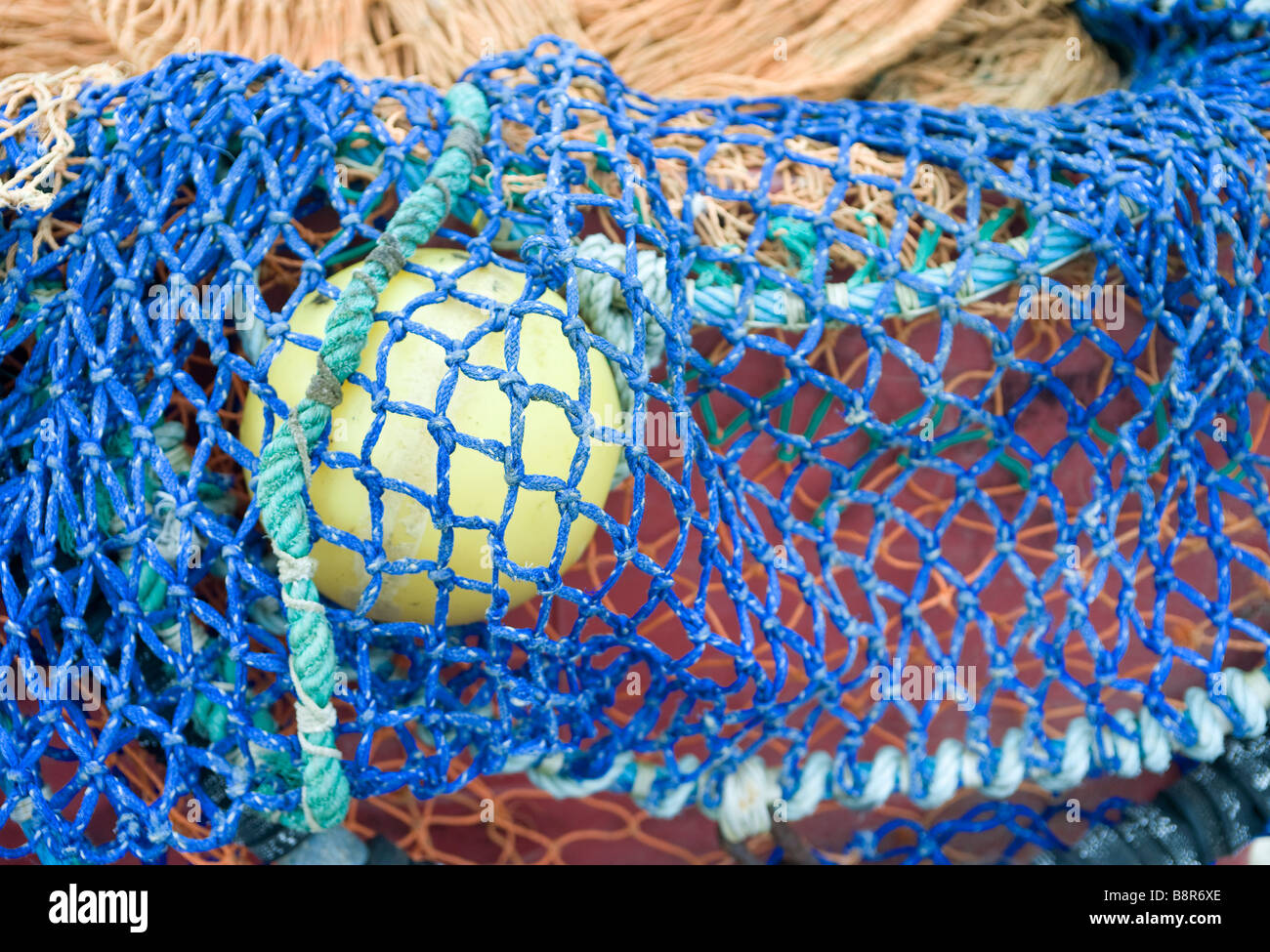 Abstrakt und Nahaufnahme von Fischernetzen mit Schwimmer, gelb blau orange grün Netz Stockfoto