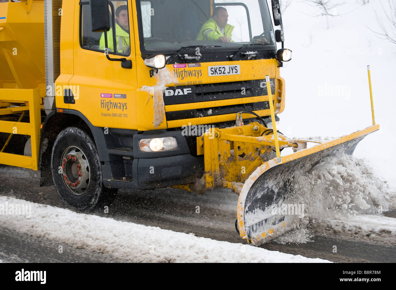 Salzstreuer LKW mit Schneepflug ausgestattet, in den Vordergrund, die Reinigung der Straßen von Schnee im ländlichen England Leicestershire Stockfoto