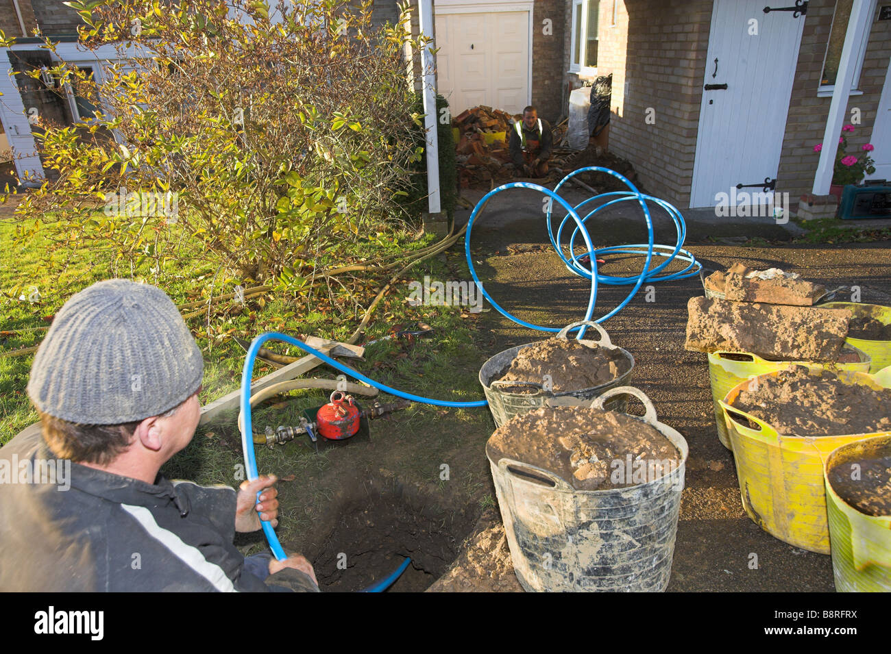 Arbeiter, die Installation neuer Hauswasserversorgung Rohr Stockfoto