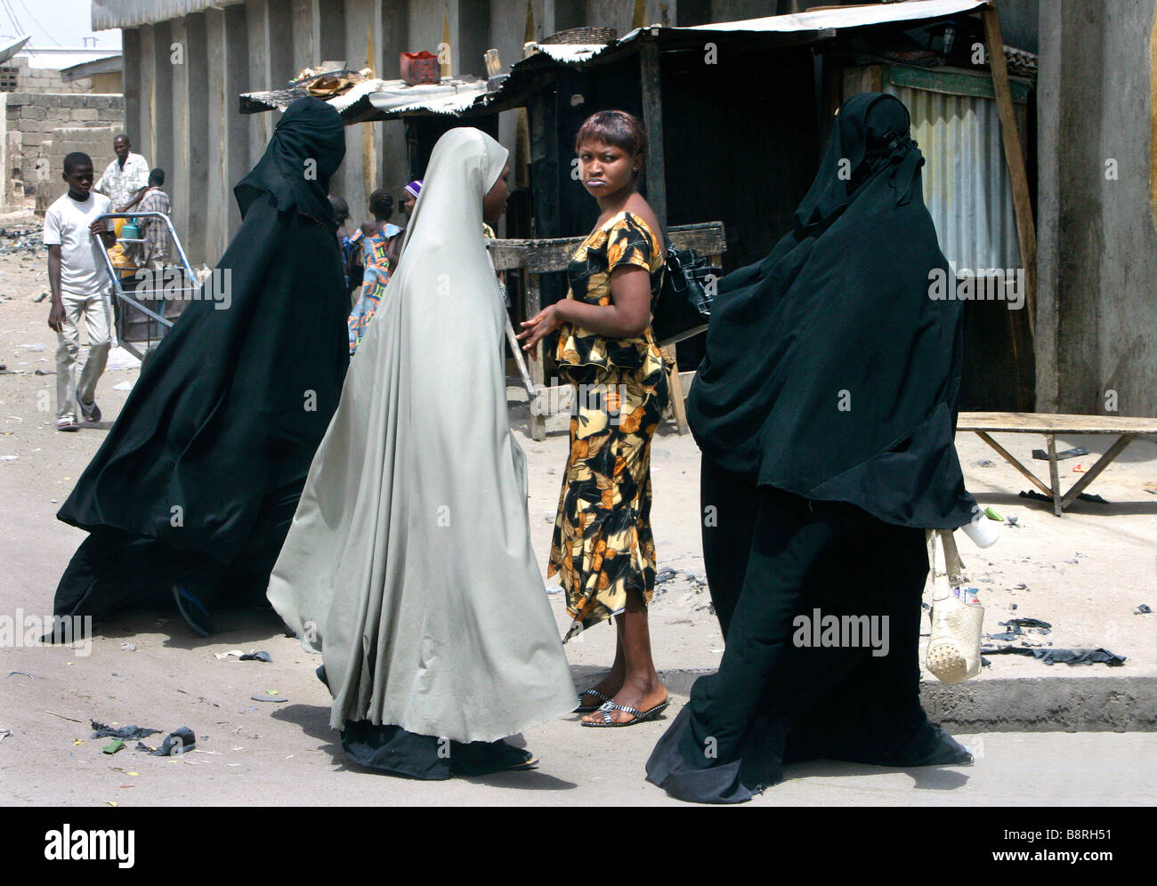 Ein skeptiker Suchen modern gekleidet christliche Frau in muslimischen Frauen das Tragen einer Burka. Maiduguri, Borno State, Nigeria Stockfoto