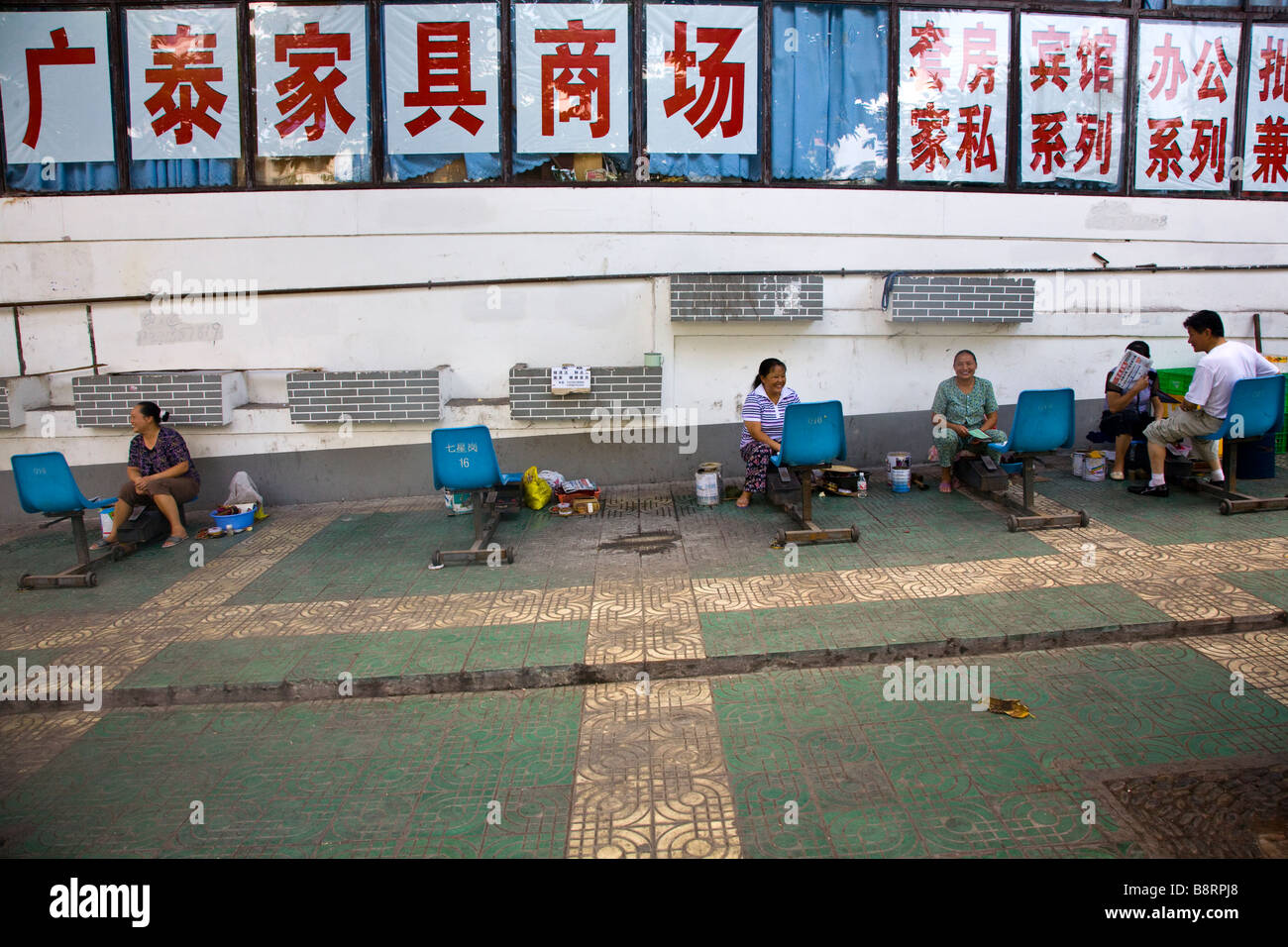 weibliche Shoepolishers auf einem Bürgersteig in Chongqing, China. Stockfoto