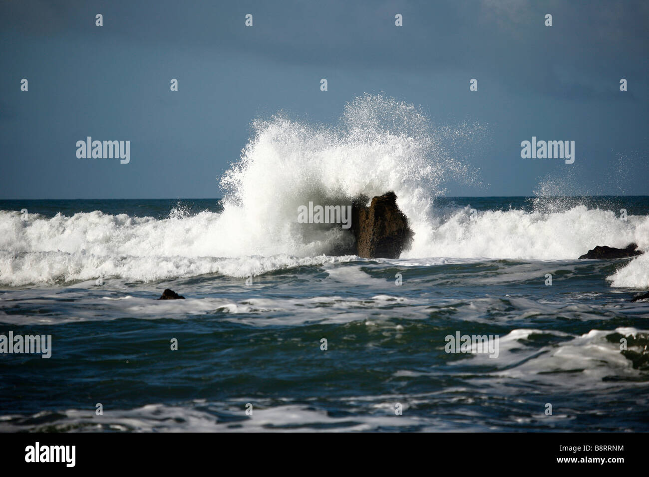 Die Welle bricht über einen Felsen Höhepunkt am Widemouth bay,Cornwall.England,UK. Stockfoto
