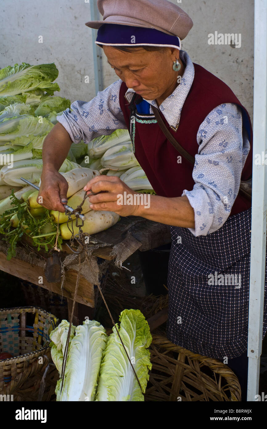 Naxi Frau verkaufen Kohl auf einem Markt in der Altstadt von Lijiang, Provinz Yunnan, China. Stockfoto