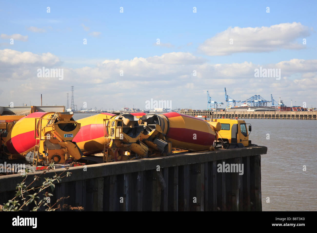 Rote und gelbe Lastwagen in ein fertiges mischen Zement Hof auf der Themse bei Gravesend Stockfoto
