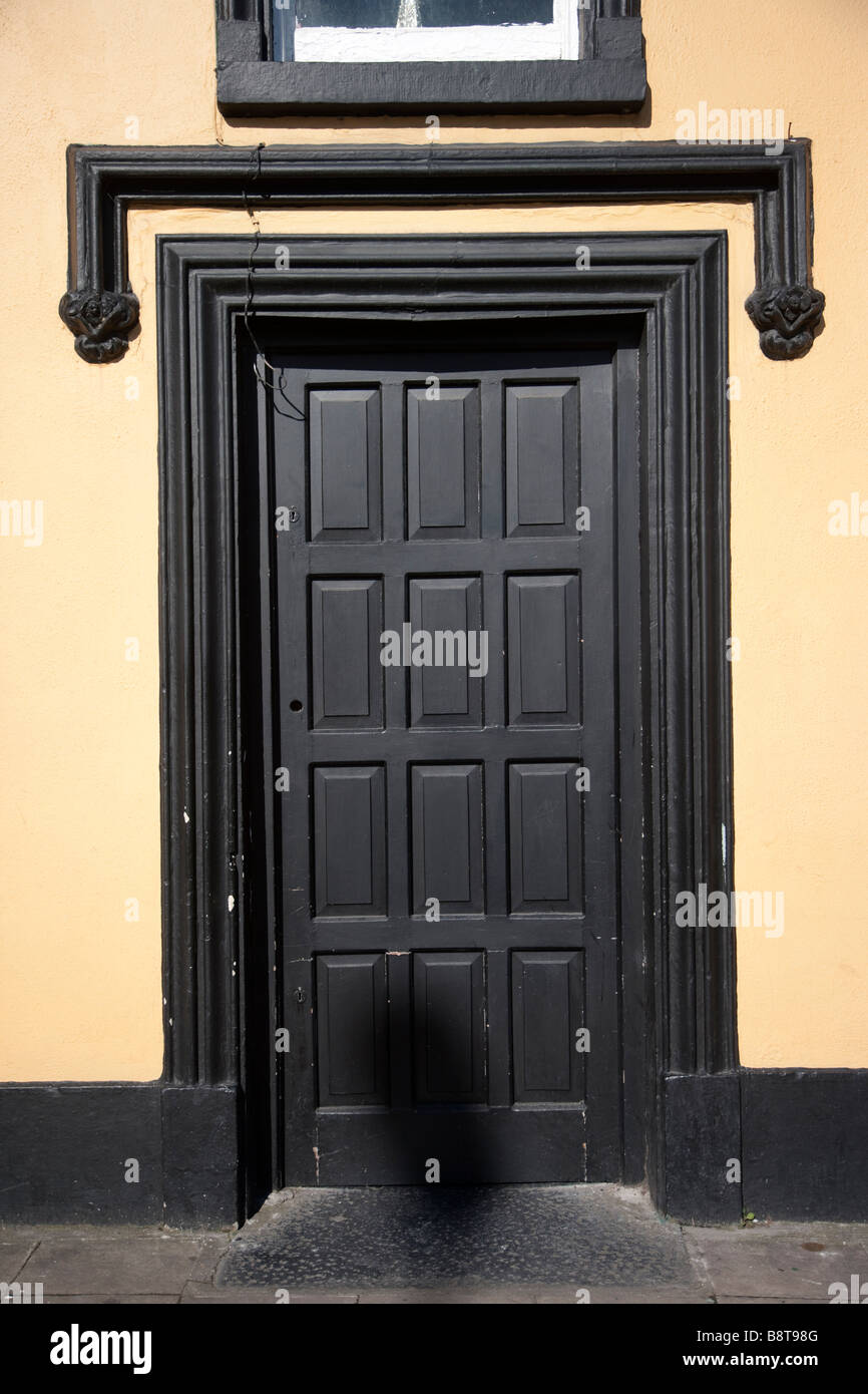 Schwarze Tür mit gelben Wand Adare Village, Irland Stockfoto