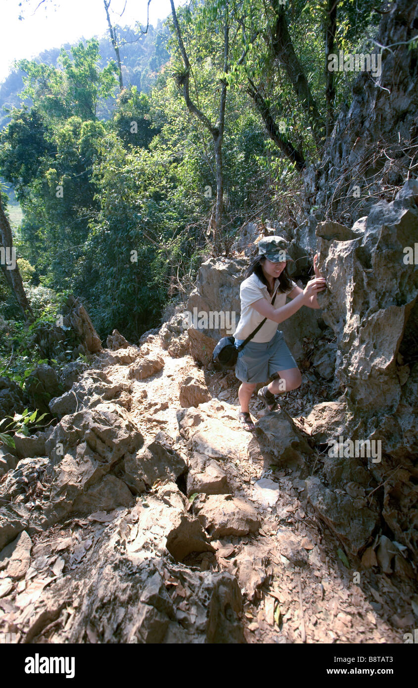 Laos, Provinz Vientiane, Vang Vieng. Frau auf Felsen. Stockfoto