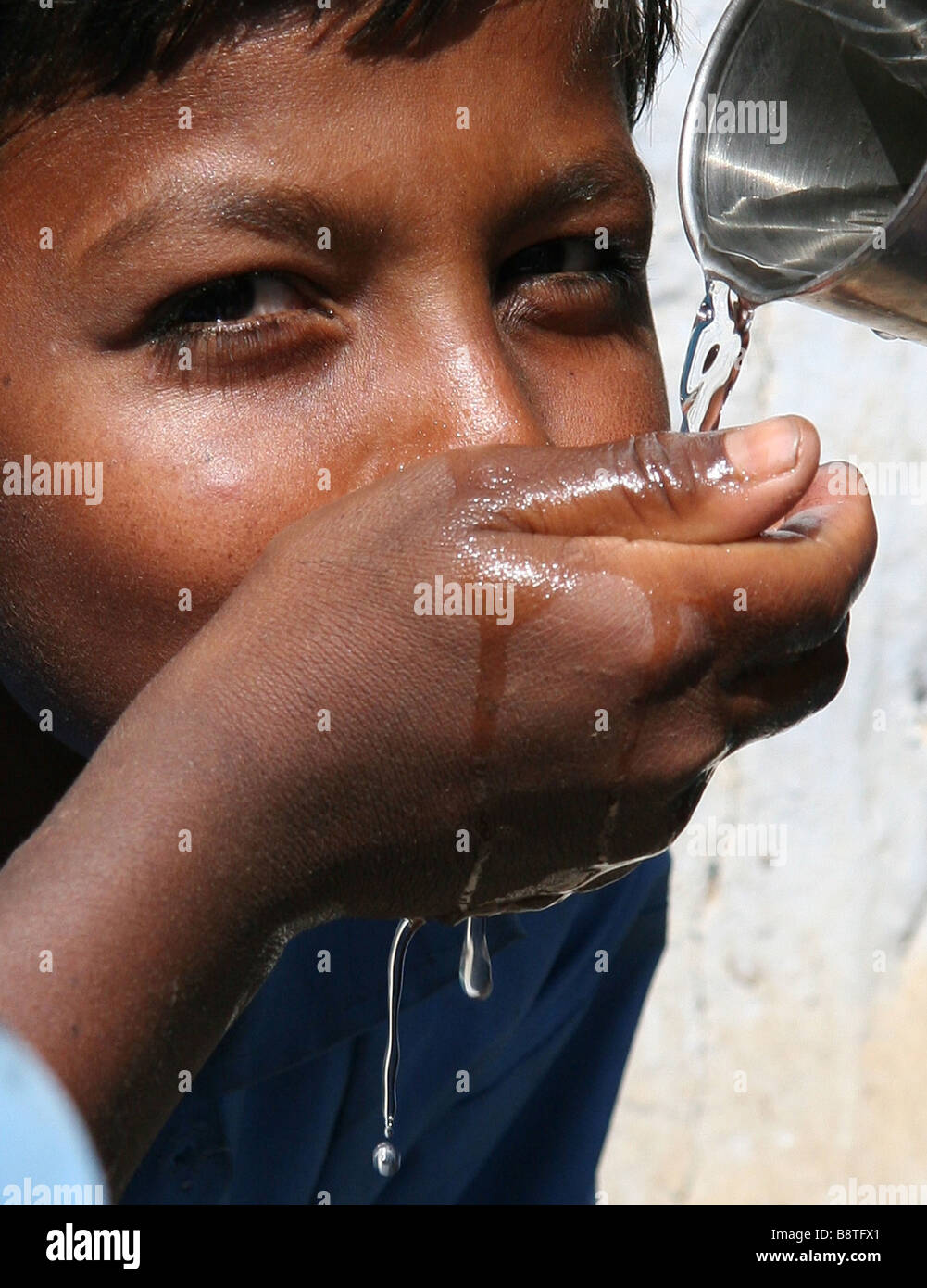Junge trinkt Wasser in der Wüste Thar, Rajasthan, Indien Stockfoto
