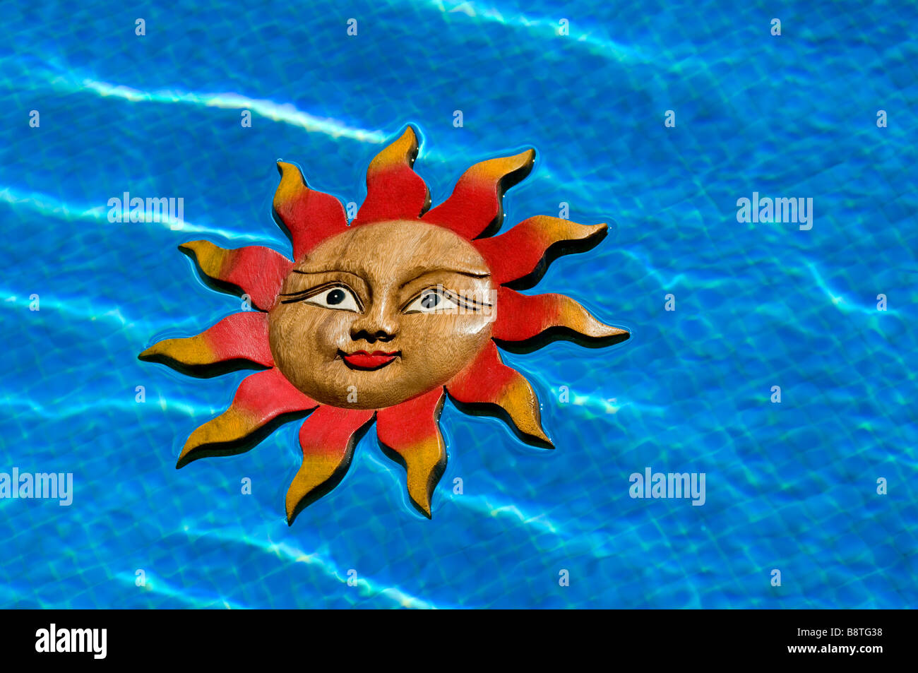 Lächelndes Gesicht Sonnensymbol schwimmenden Schwimmbad inmitten sonnigen blauen Urlaub Urlaub Stockfoto