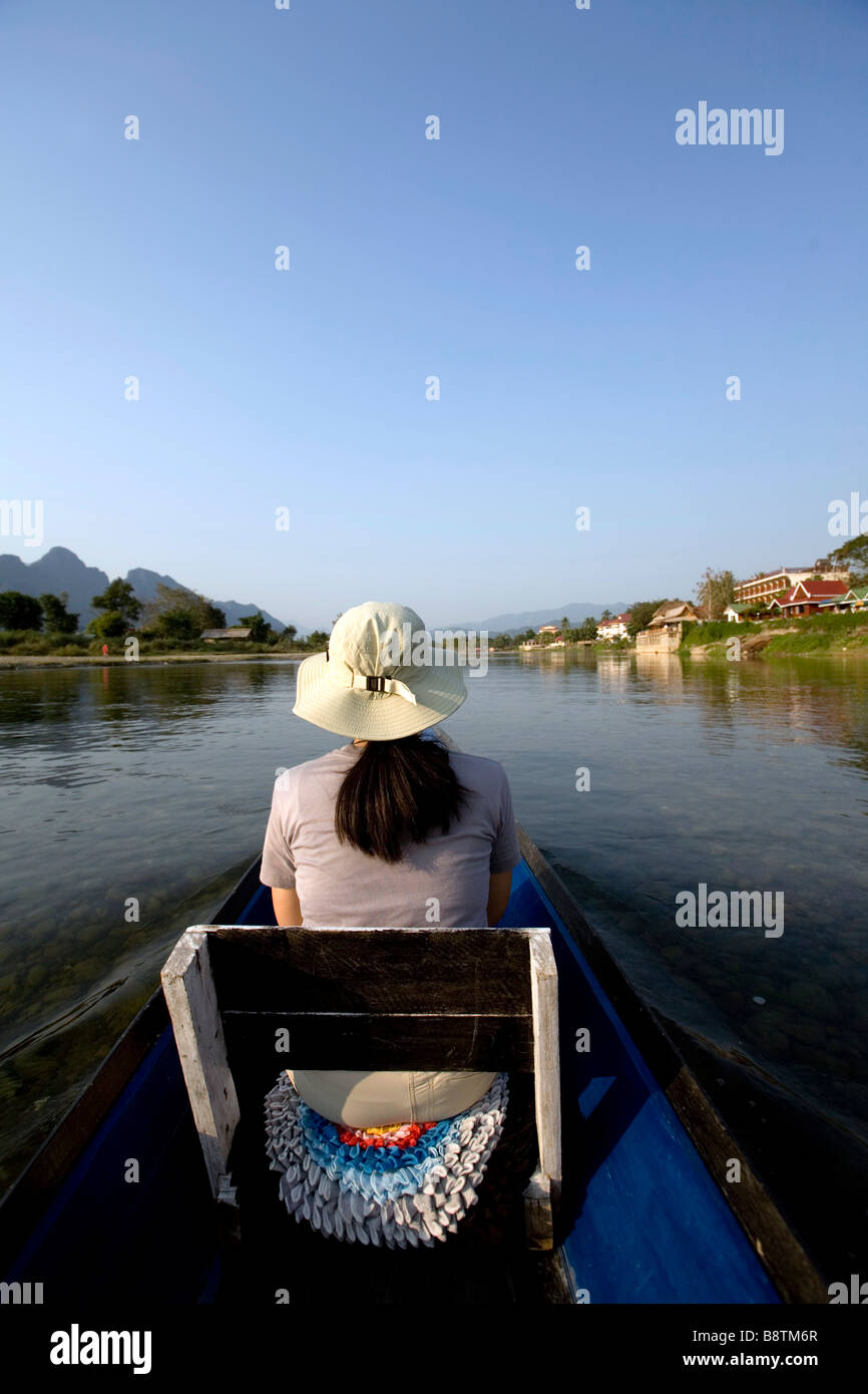 Laos, Vientiane Provinz, Vang Vieng, Nam Song River, Frau am Boot, Kalksteinhügel. Stockfoto