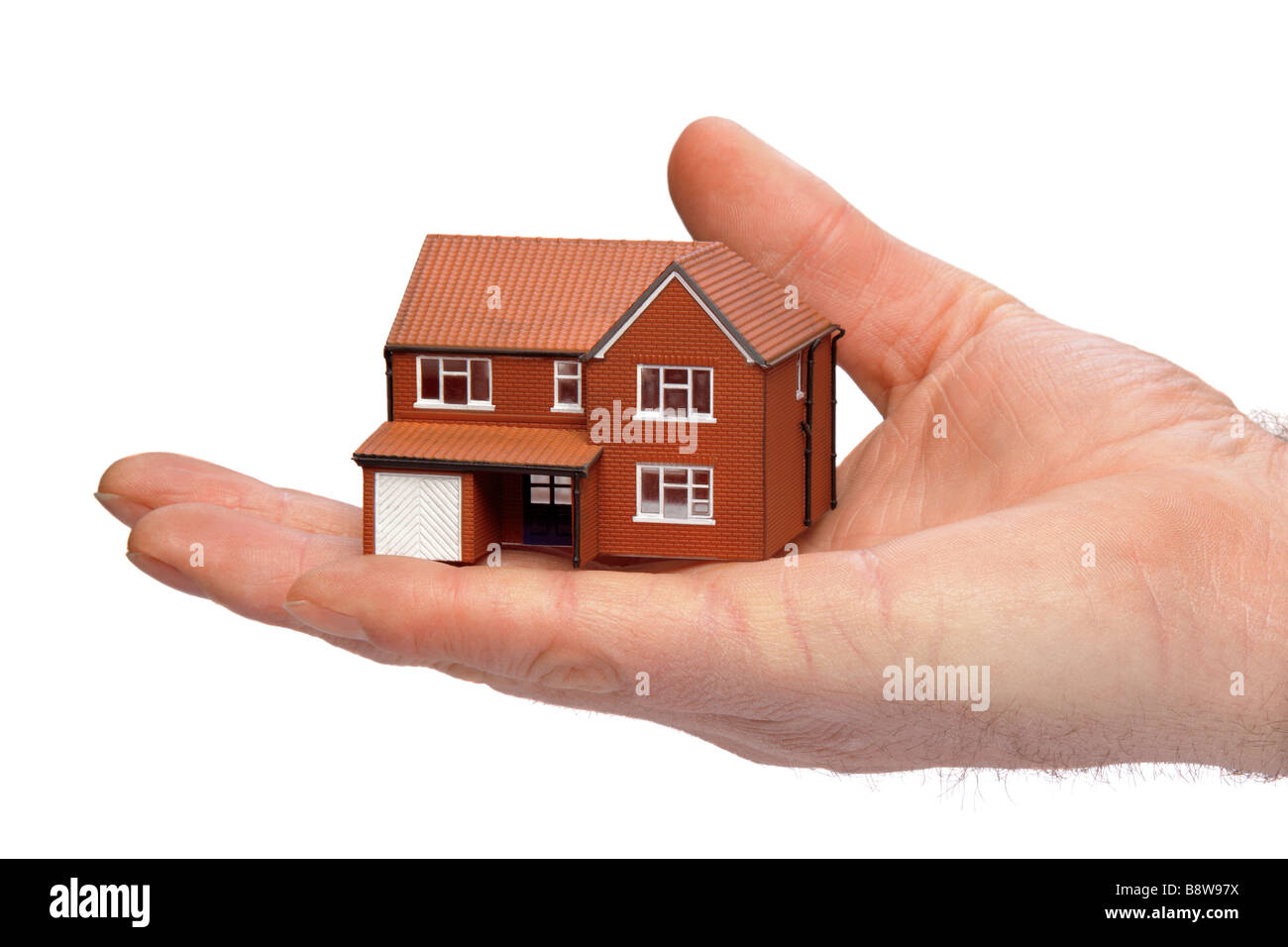 Hand hält eine Miniatur modernes Einfamilienhaus auf einem weißen Hintergrund isoliert Stockfoto