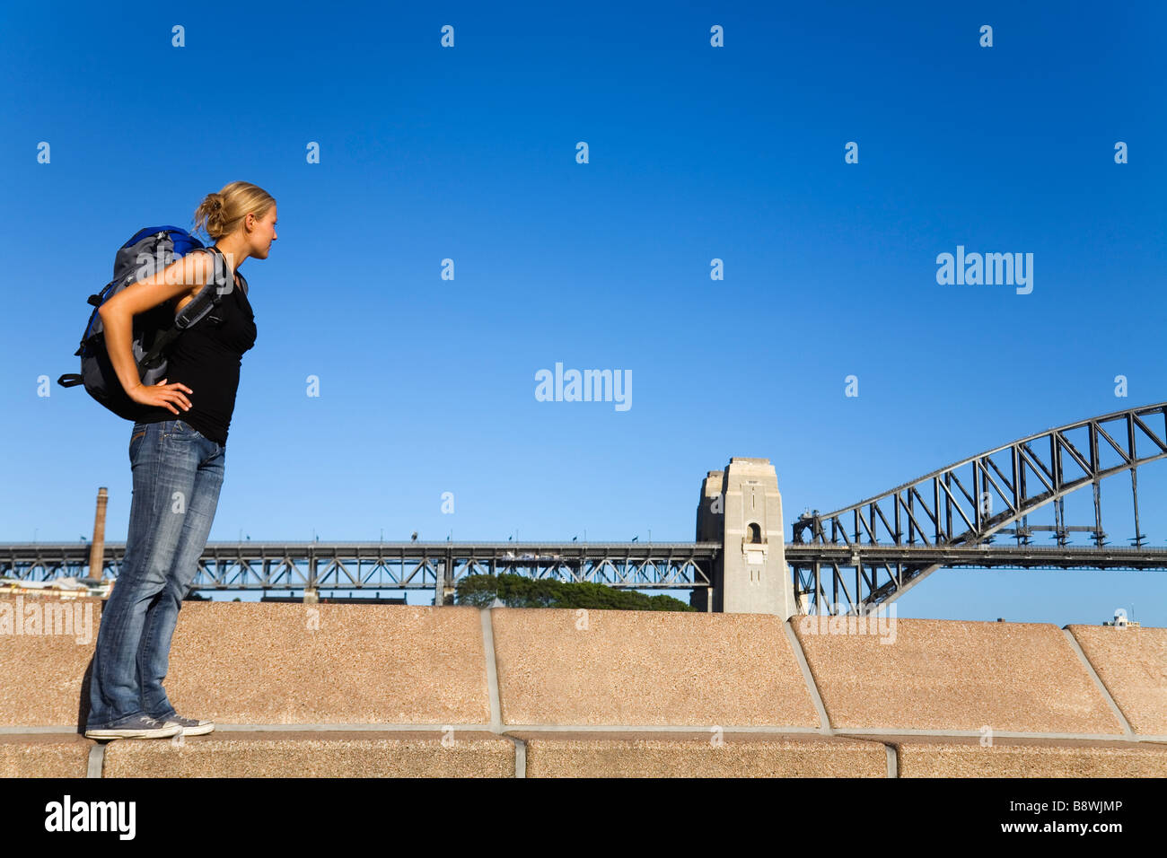 Ein Backpacker auf Sydney Harbour mit der Harbour Bridge hinaus.  Sydney, New South Wales, Australien Stockfoto