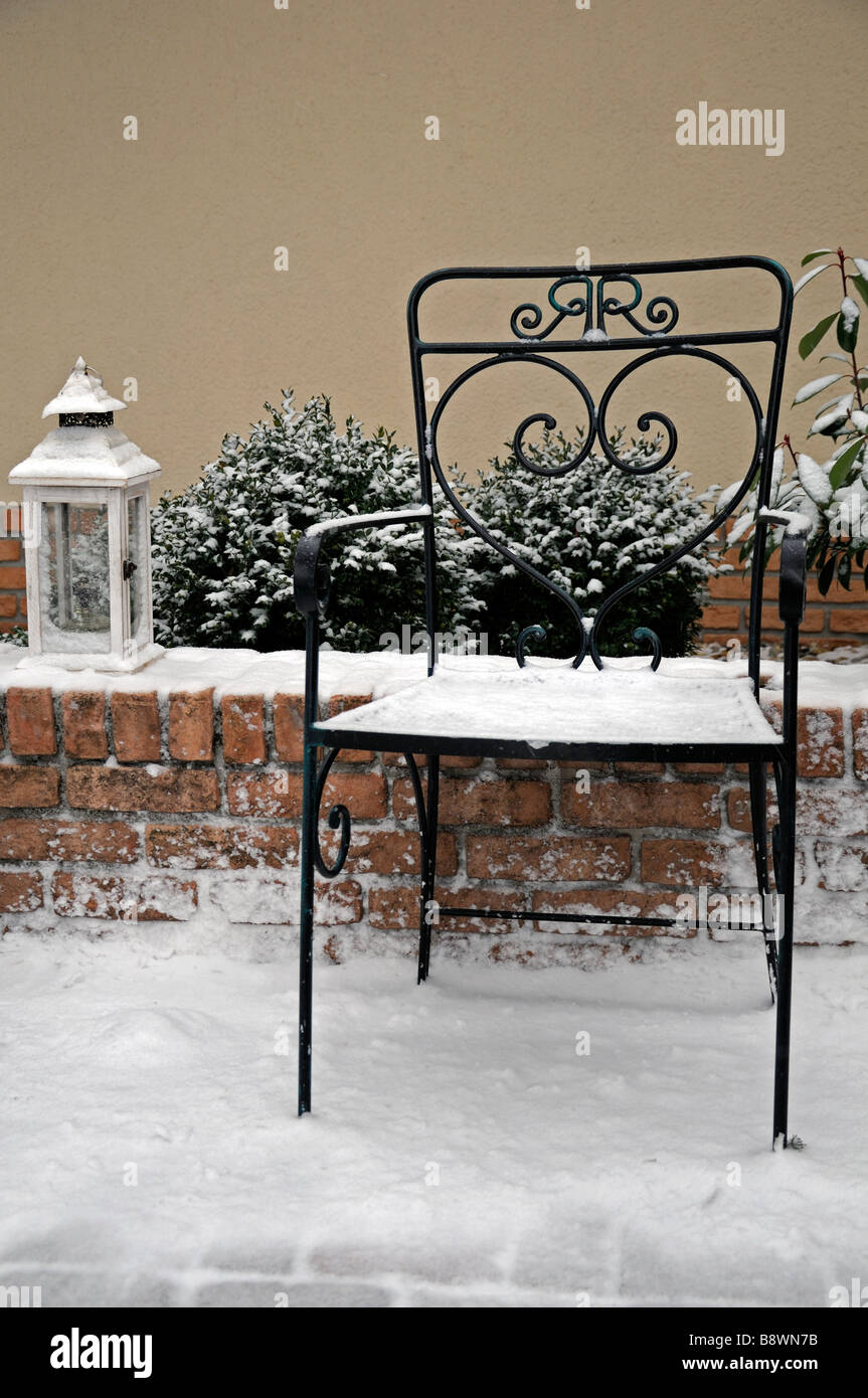 rustikale Schmiedeeisen Garten-Sitzplatz und eine helle Lampe Laterne Abdeckung bedeckt mit Schnee-Winter-Wunderland Stockfoto
