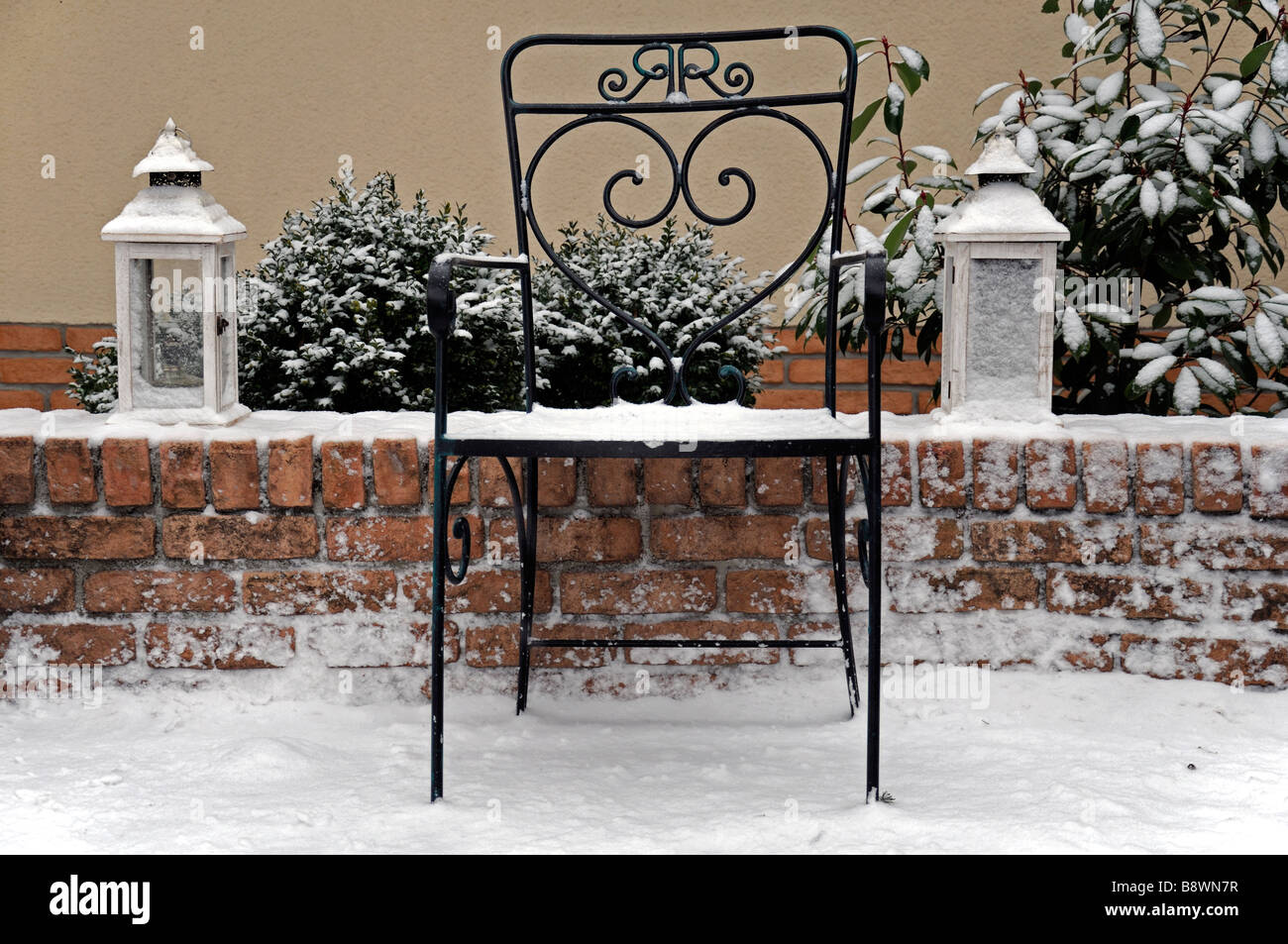 rustikale Schmiedeeisen Garten-Sitzplatz und zwei Leuchten Lampen Laterne Laternen Licht Abdeckung bedeckt mit Schnee-Winter-Wunderland Stockfoto