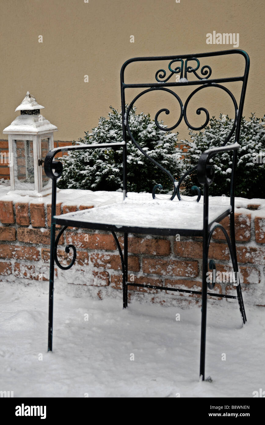 rustikale Schmiedeeisen Garten-Sitzplatz und eine helle Lampe Laterne Abdeckung bedeckt mit Schnee-Winter-Wunderland Stockfoto
