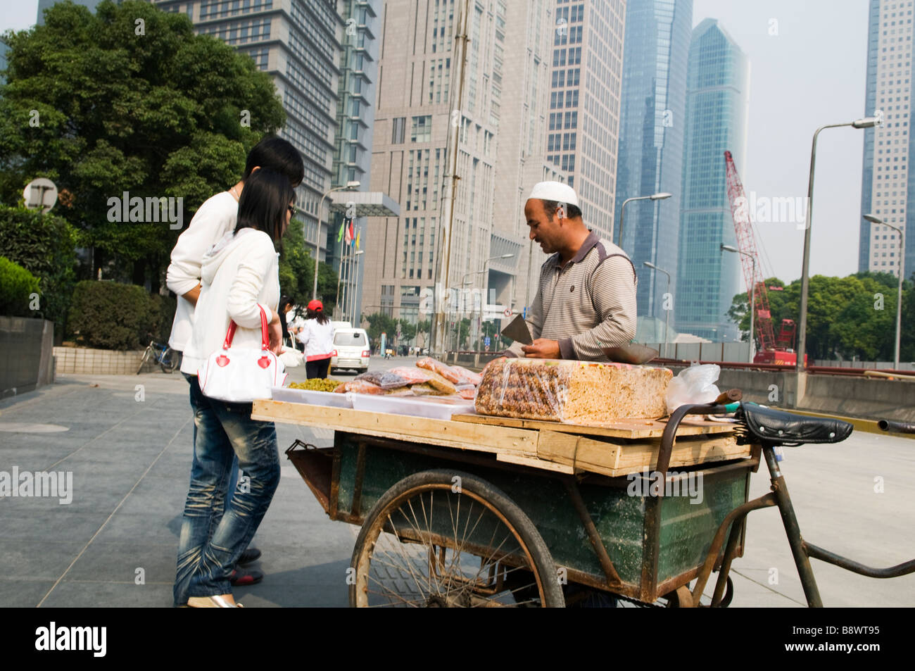 Ein Uyghur (Uygur) Mann aus der Provinz Xinjiang verkauft Nüssen und Süßigkeiten von Xinjiang in der Luijiazui finanziellen Bezirk Pudong Stockfoto