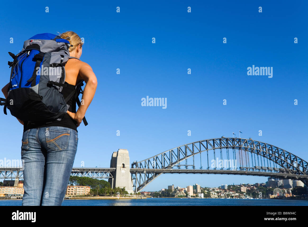 Eine Backpacker schaut über Sydney Cove zur Harbour Bridge.  Sydney, New South Wales, Australien Stockfoto