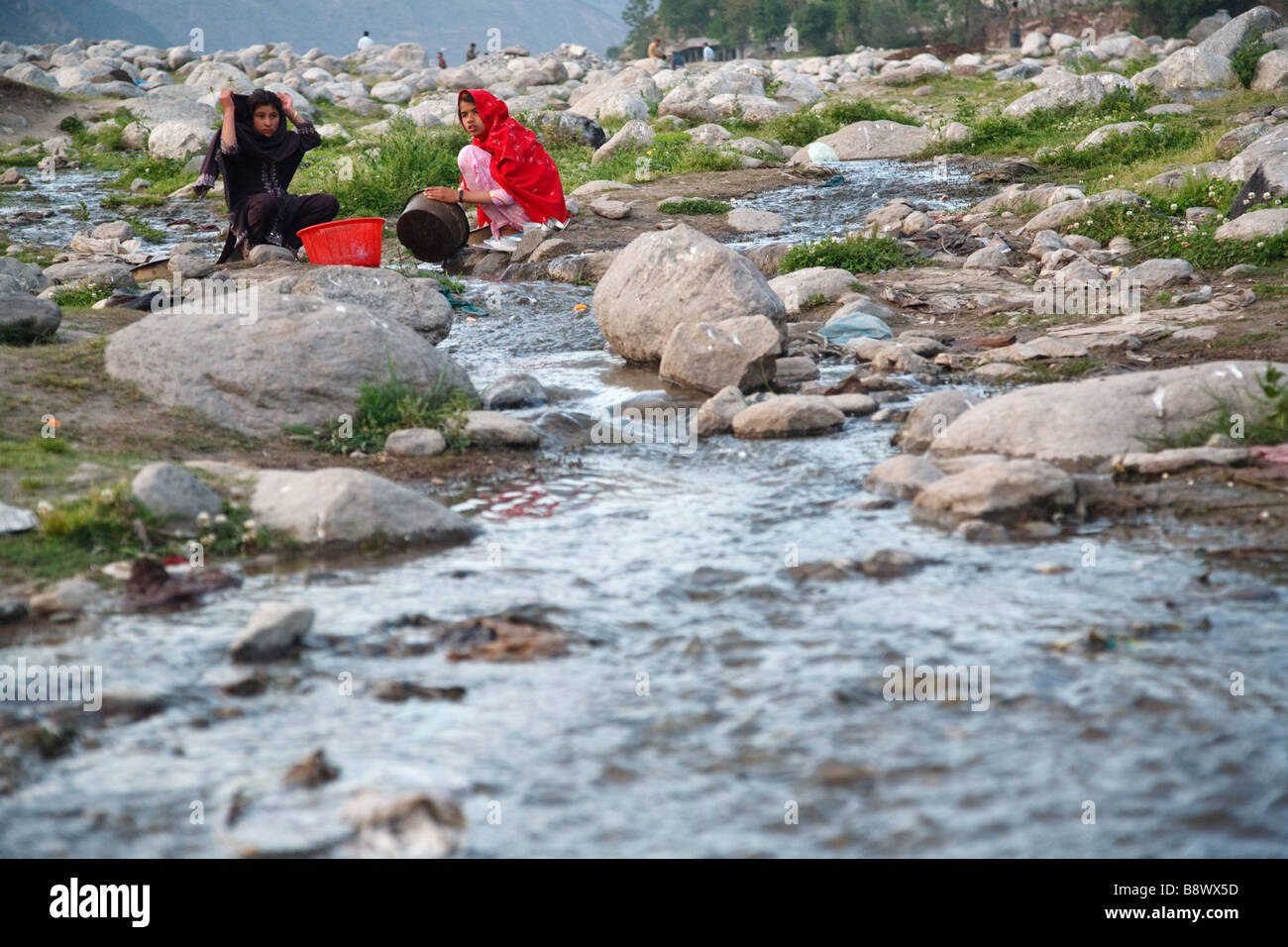 Frauen Wäsche in einem Bach in einem Flüchtlingslager in Balakot, Pakistan, sechs Monate nach dem Erdbeben in Kaschmir Stockfoto