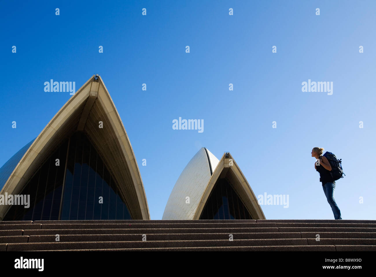 Ein Backpacker auf den Stufen des Opernhauses in Sydney, New South Wales, Australien. Stockfoto