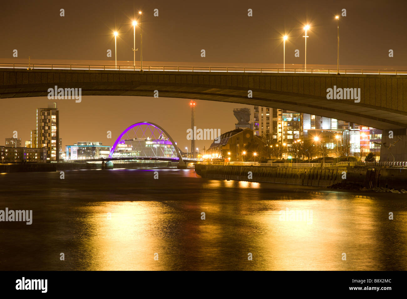Blick unter die Kingston Bridge in Glasgow gegen Clyde Arc (Squinty Brücke) in der Nacht Stockfoto