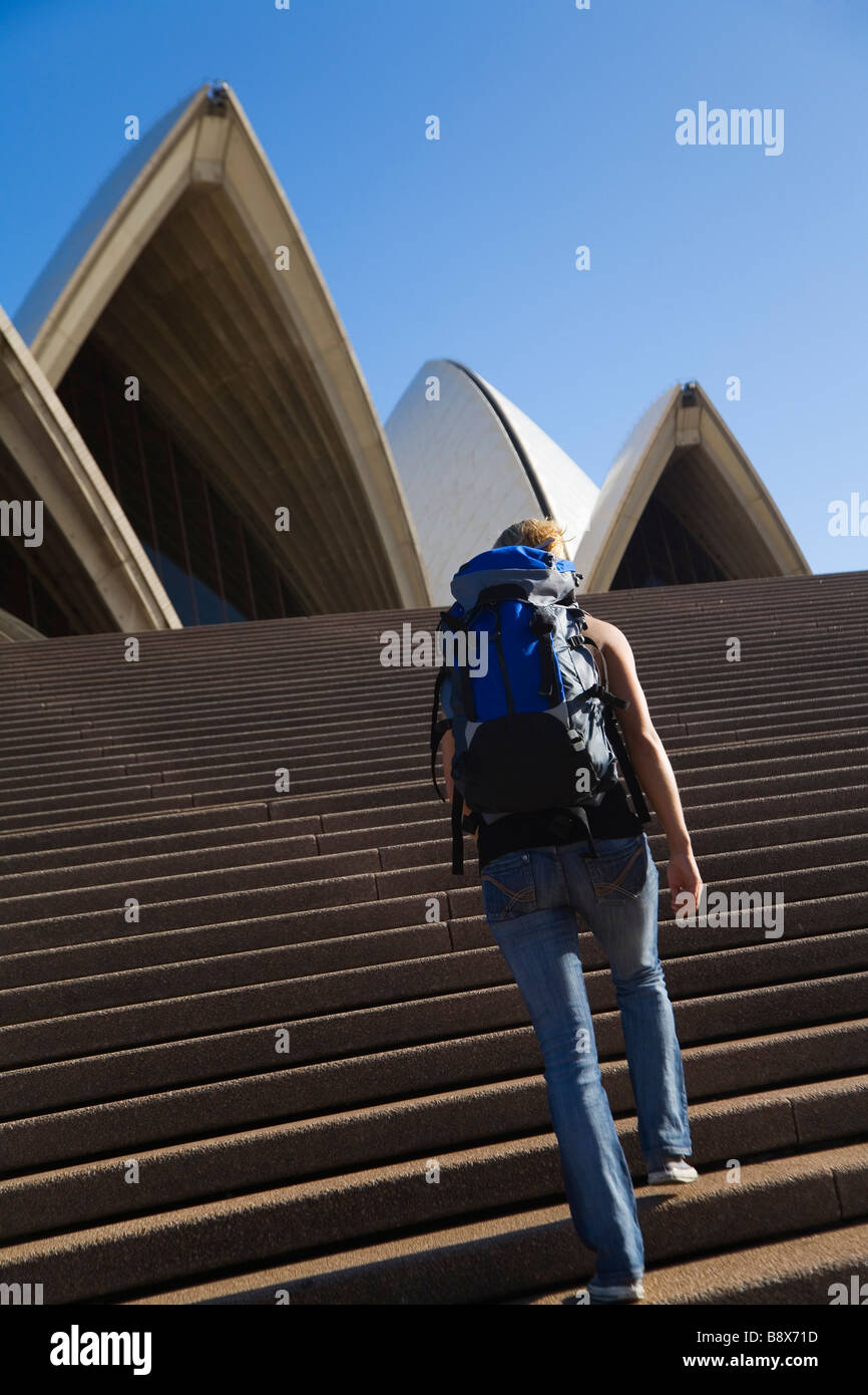 Eine Backpacker steigt die Stufen des Opernhauses in Sydney, New South Wales, Australien. Stockfoto