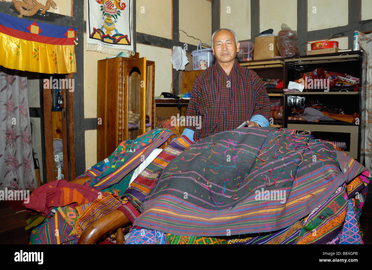 Ein Trader zeigt seinen Bestand an handgewebten Seidentuch Stockfoto