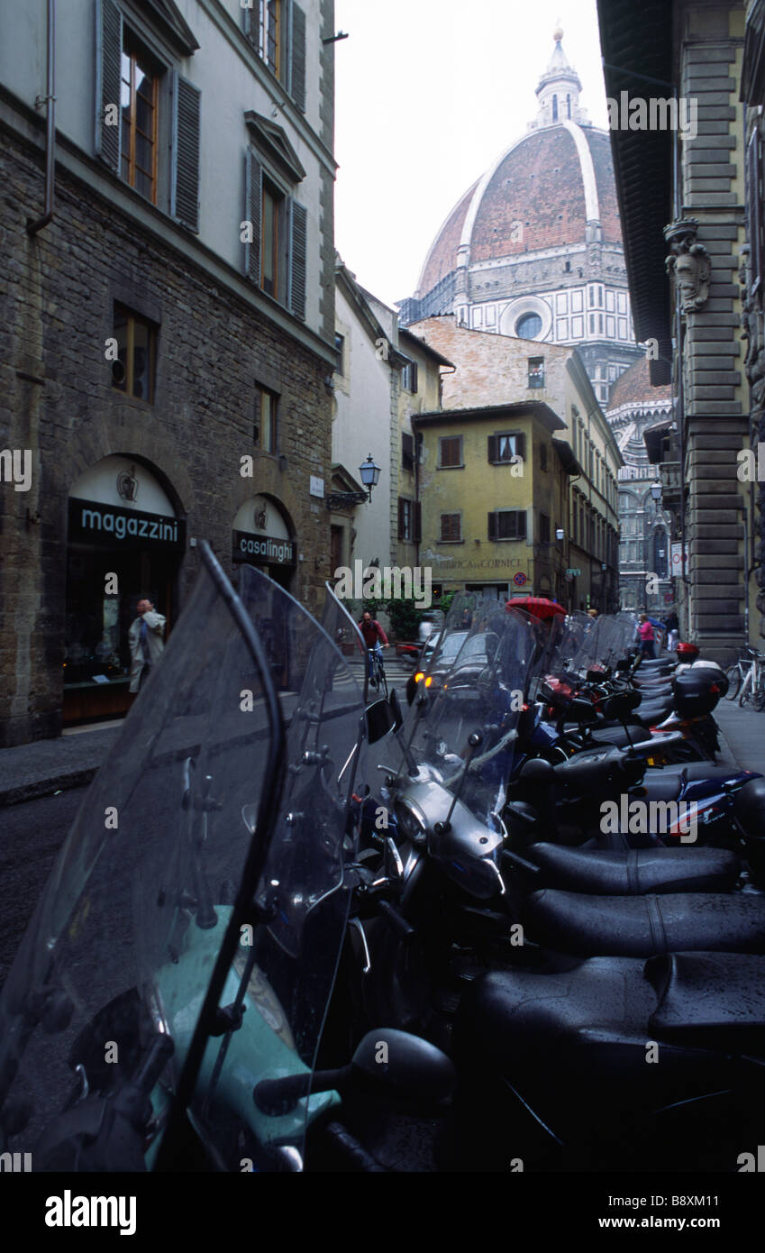 Typische Straßenszene in Florenz Italien zeigt geparkten Vespas oder Roller und dem Dom im Hintergrund Stockfoto