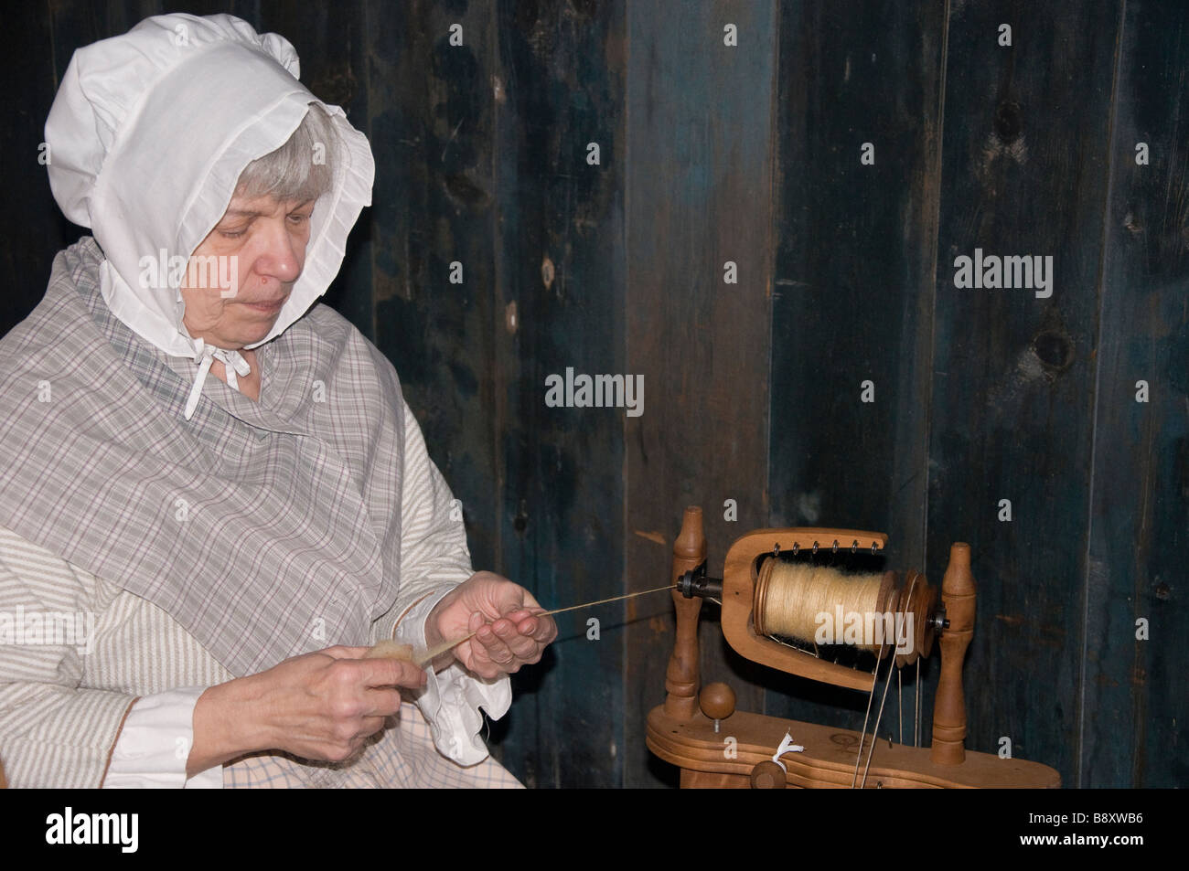 Eine ältere Frau, gekleidet in Pionier Kleidung sitzt und Wolle spinnen.  Kein Model-Release - erfordert nur zur redaktionellen Verwendung  Stockfotografie - Alamy