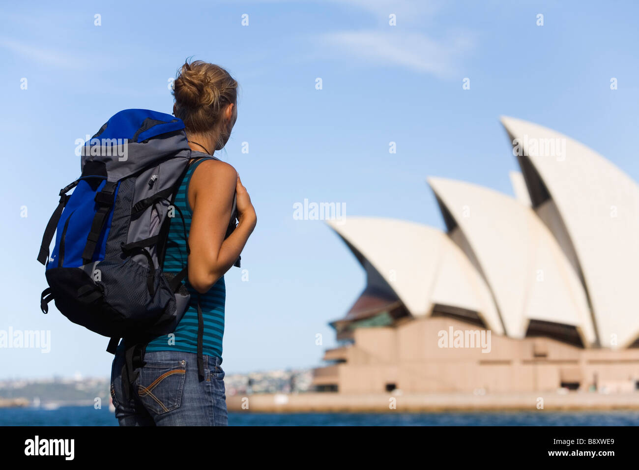 Eine Backpacker sieht durch den Hafen von Sydney Opera House.  Sydney, New South Wales, Australien Stockfoto