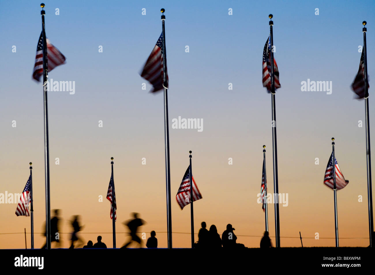 Kinder laufen. Amerikanische Flaggen am Washington Monument mit Besuchern bei Sonnenuntergang. Washington DC USA. Stockfoto