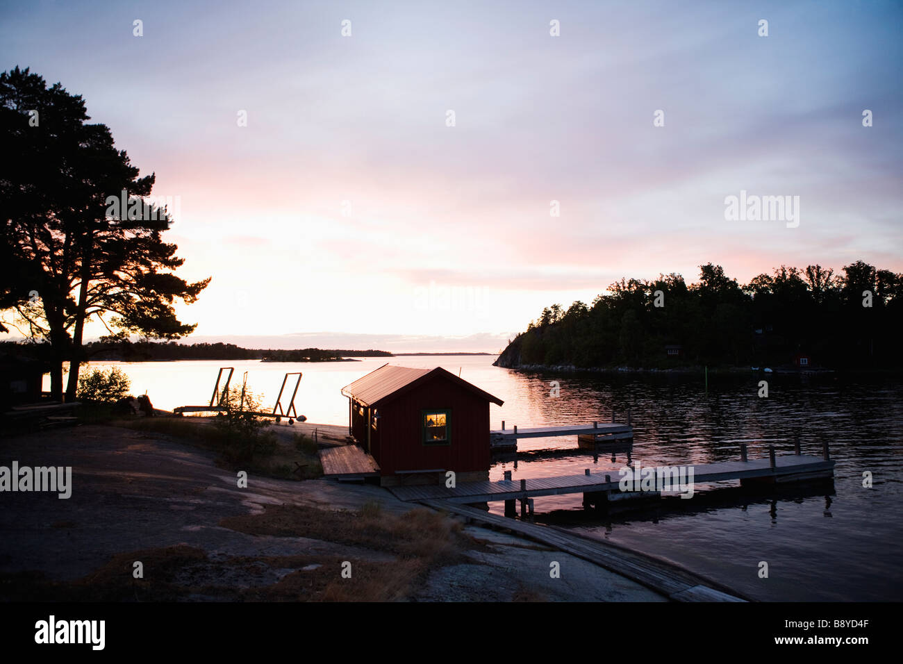 Ein Bootshaus in den Sonnenuntergang in den Schären von Stockholm Schweden. Stockfoto