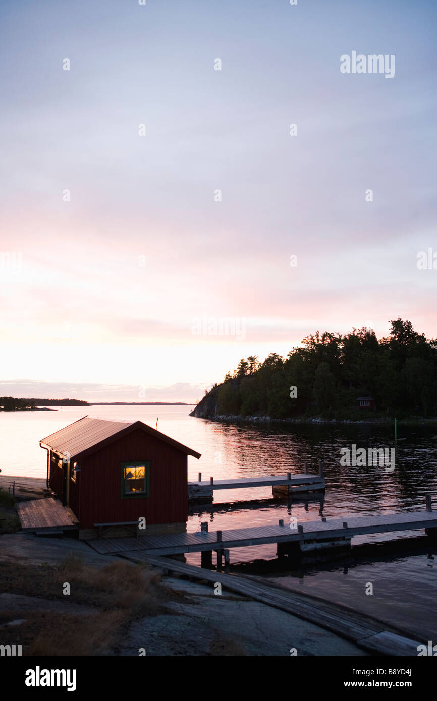 Ein Bootshaus in den Sonnenuntergang in den Schären von Stockholm Schweden. Stockfoto