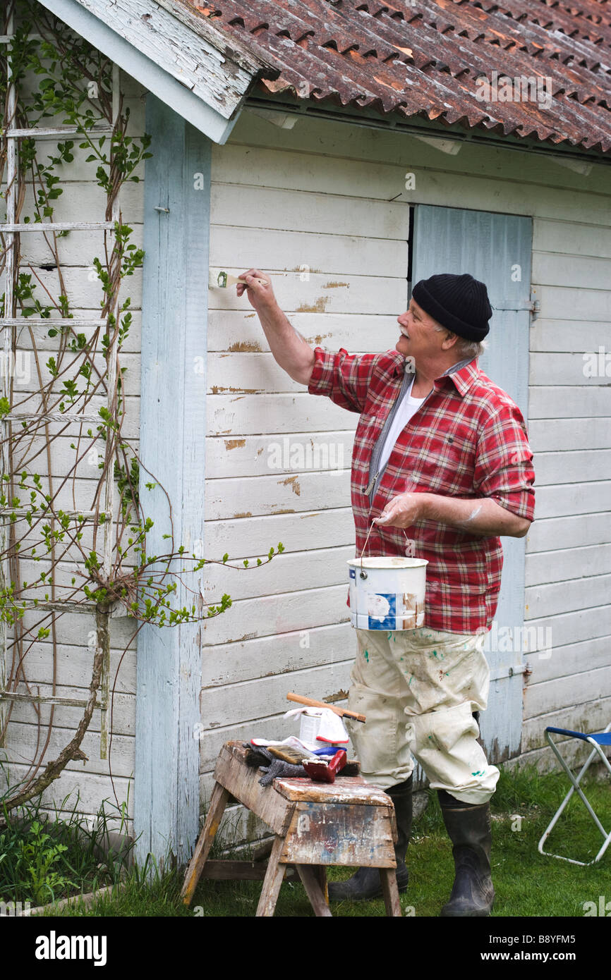 Älterer Mann seinem Sommerhaus Schweden Malerei. Stockfoto