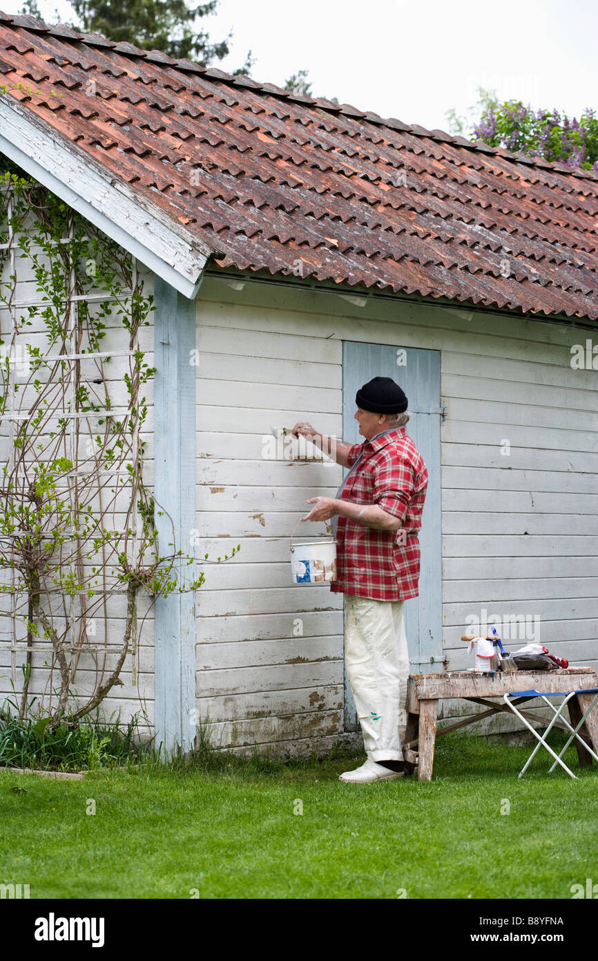 Älterer Mann seinem Sommerhaus Schweden Malerei. Stockfoto