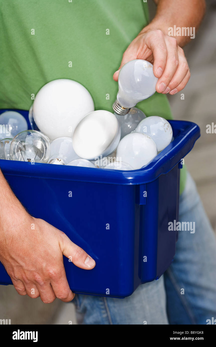 Ein Mann hält Glühbirnen für das recycling. Stockfoto