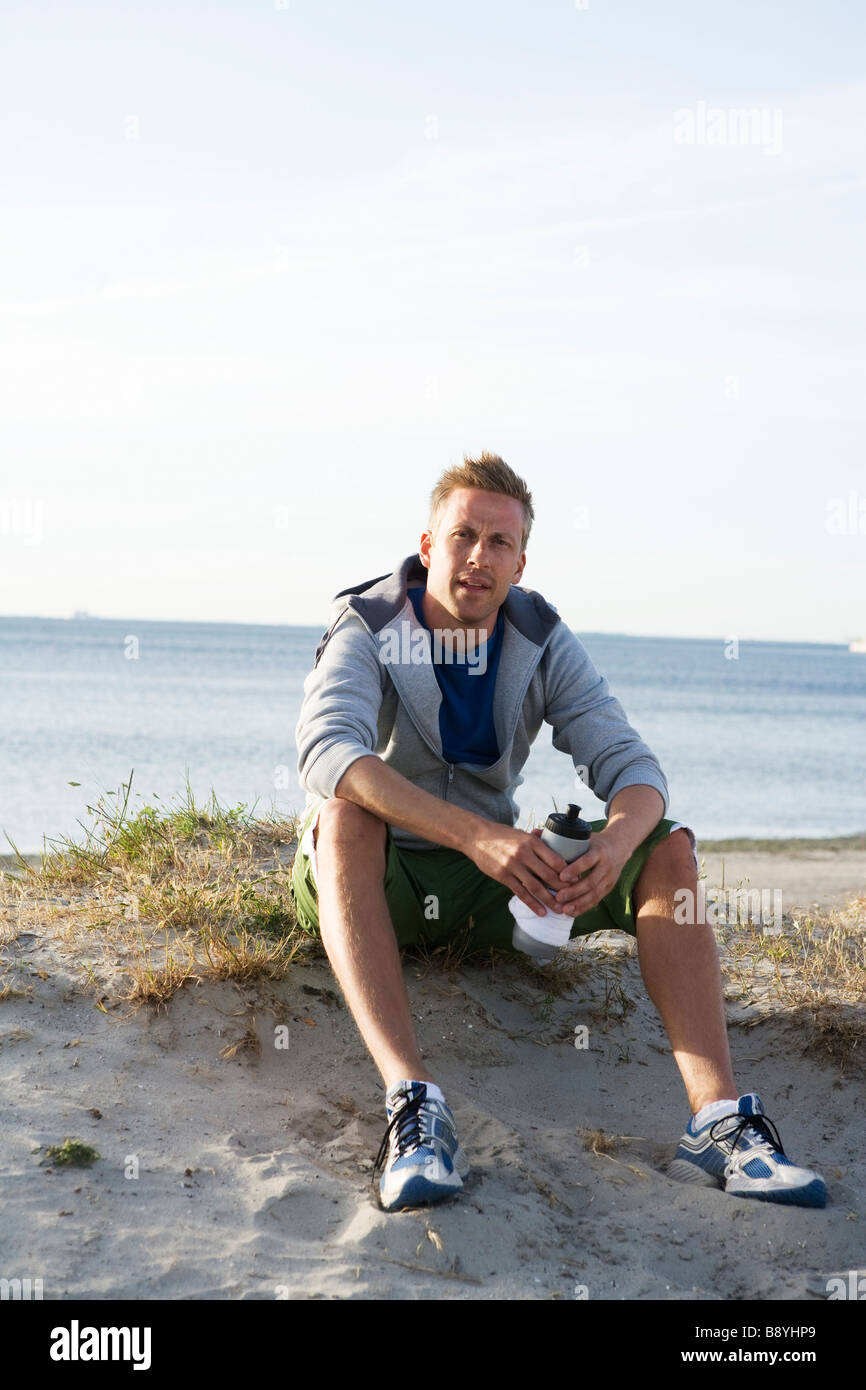 Ein Mann nach dem Joggen am Strand Malmö Schweden ruhen. Stockfoto