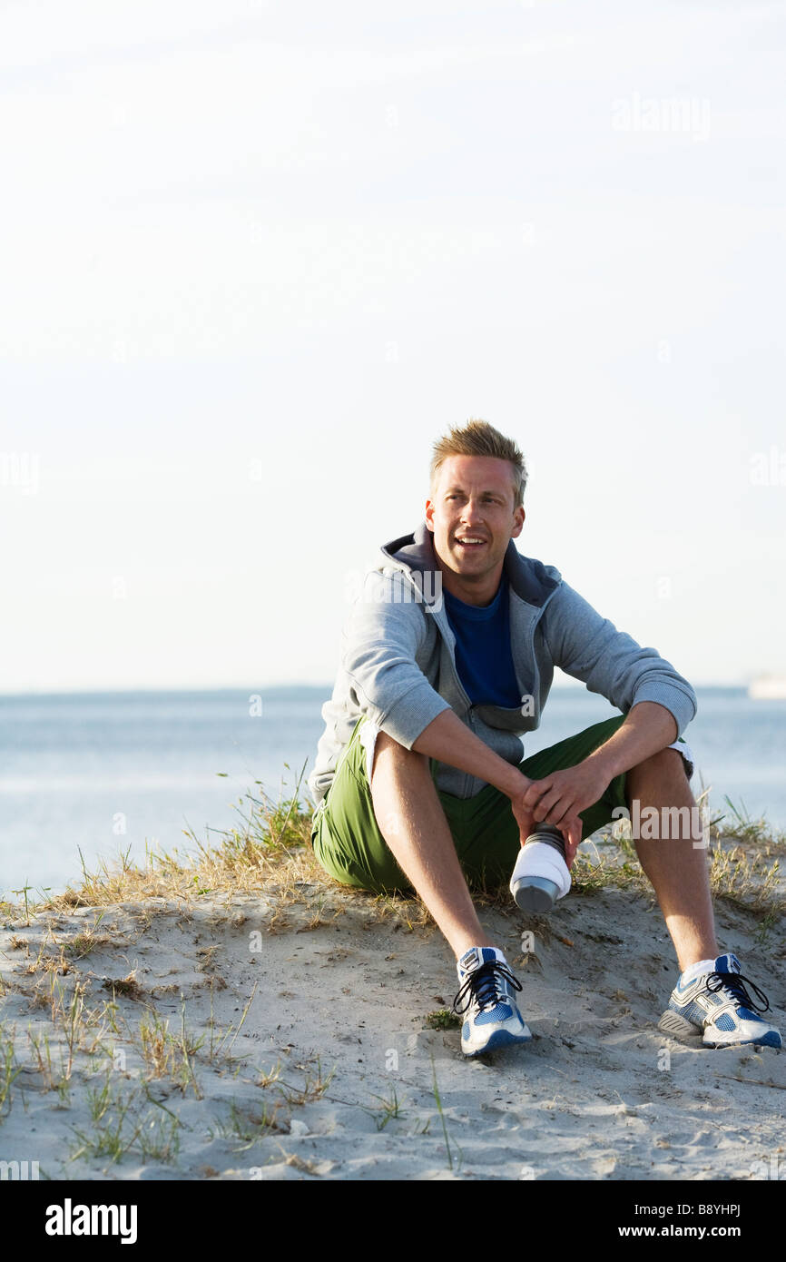 Ein Mann nach dem Joggen am Strand Malmö Schweden ruhen. Stockfoto