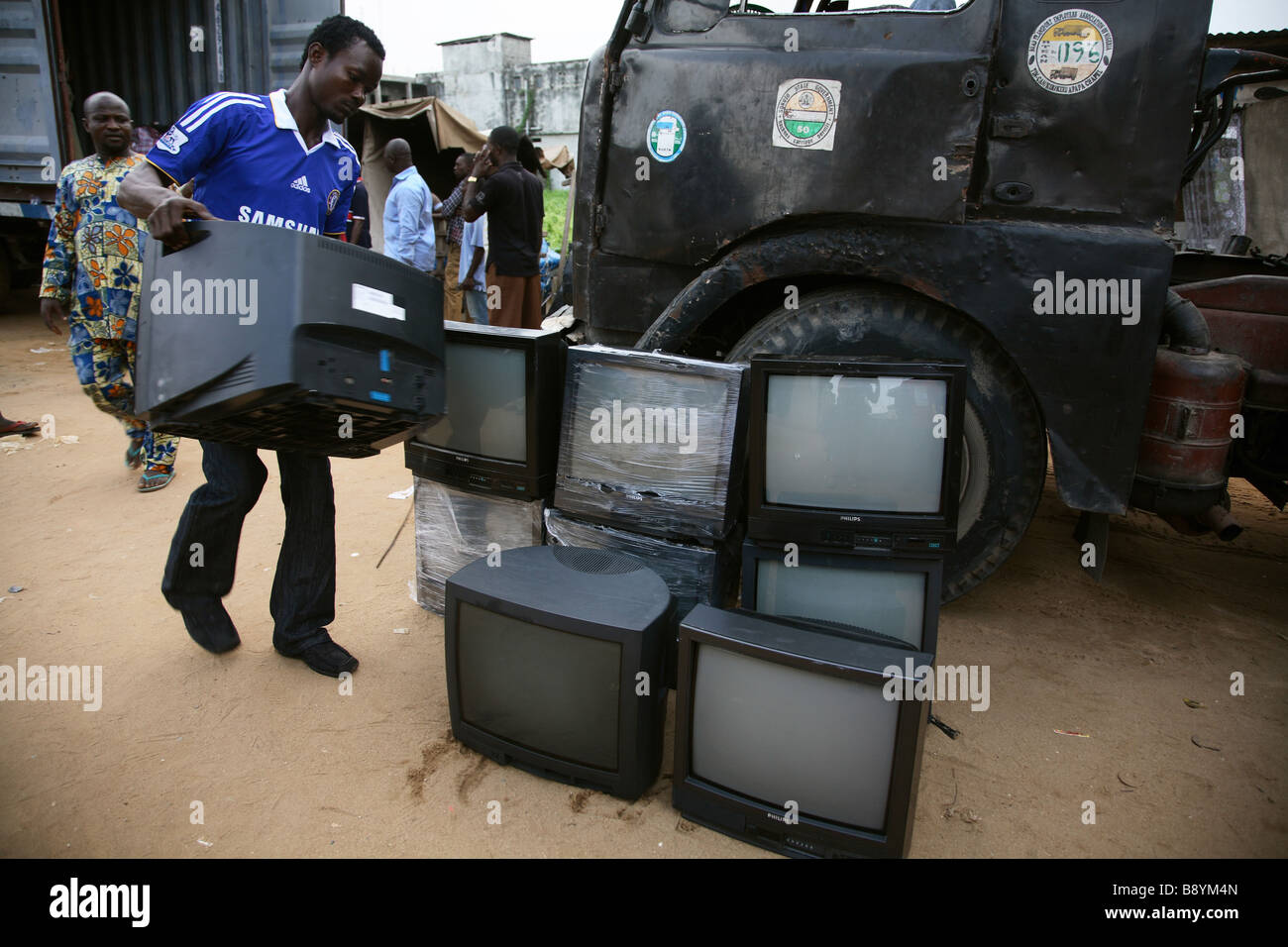 Ein Container mit zweiter hand TVs aus England wird geleert und die Fernseher sind für Käufer auf dem Boden gestapelt werden. Stockfoto