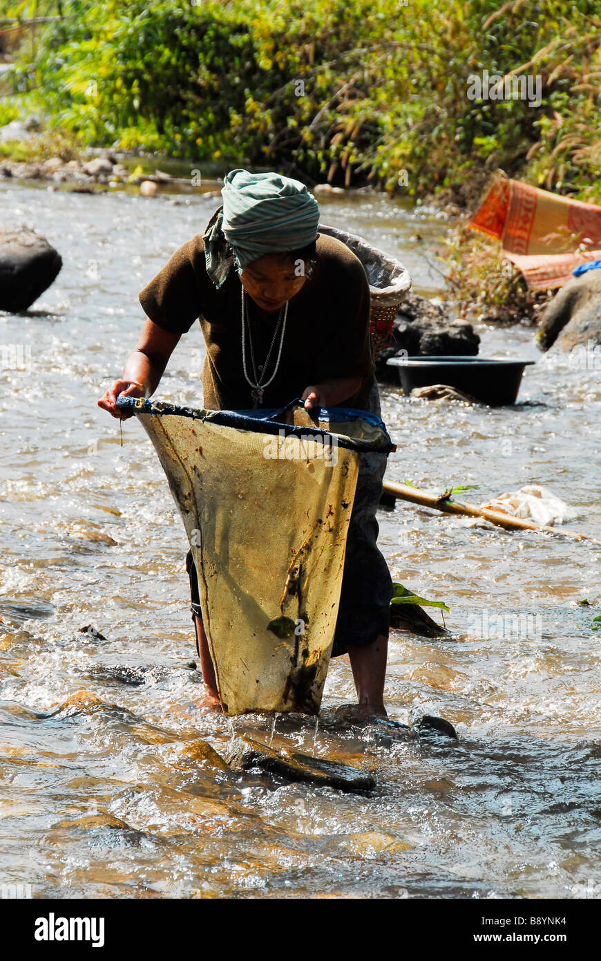 Karen Flüchtling Dame Fang von Fischen mit Netz im Fluss in der Nähe von Maela Refugee Camp, Tak, Nord-Thailand. Stockfoto