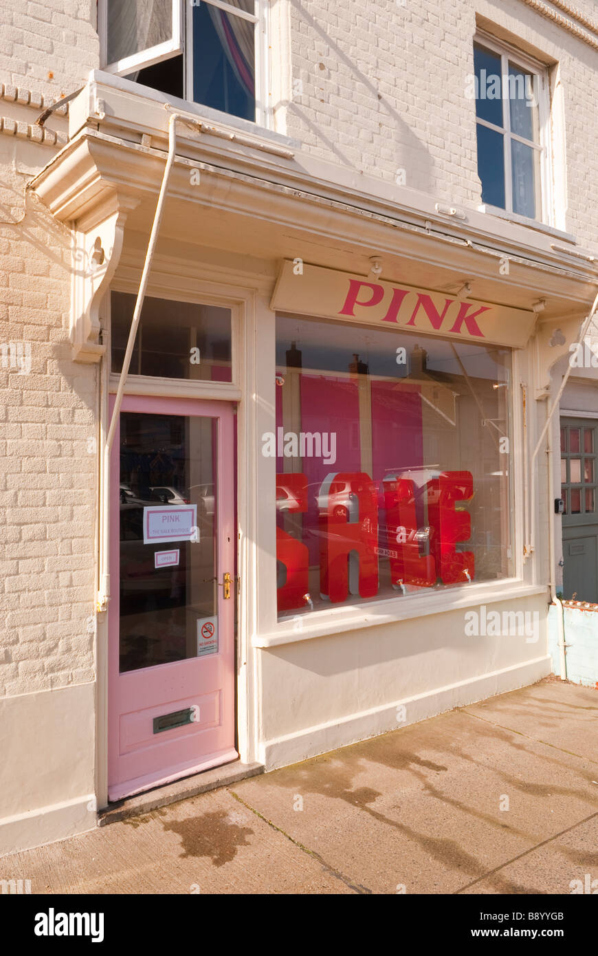 Rosa Damen Kleidung Shop speichern verkauft Kleidung für Frauen mit einem Verkaufsschild im Fenster in Aldeburgh, Suffolk, Uk Stockfoto