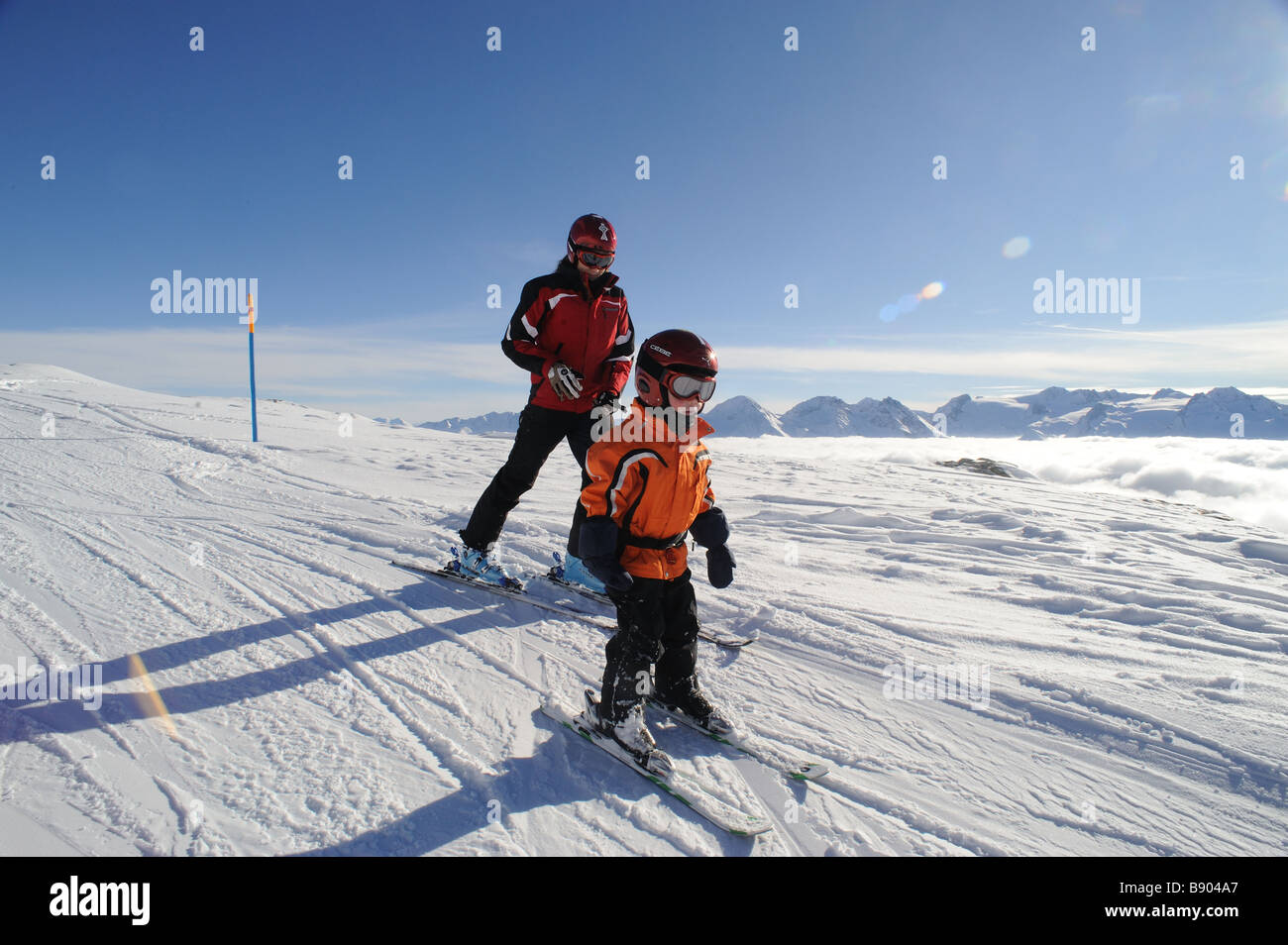 Kleiner Junge von seiner Schwester Skifahren lernen Stockfoto