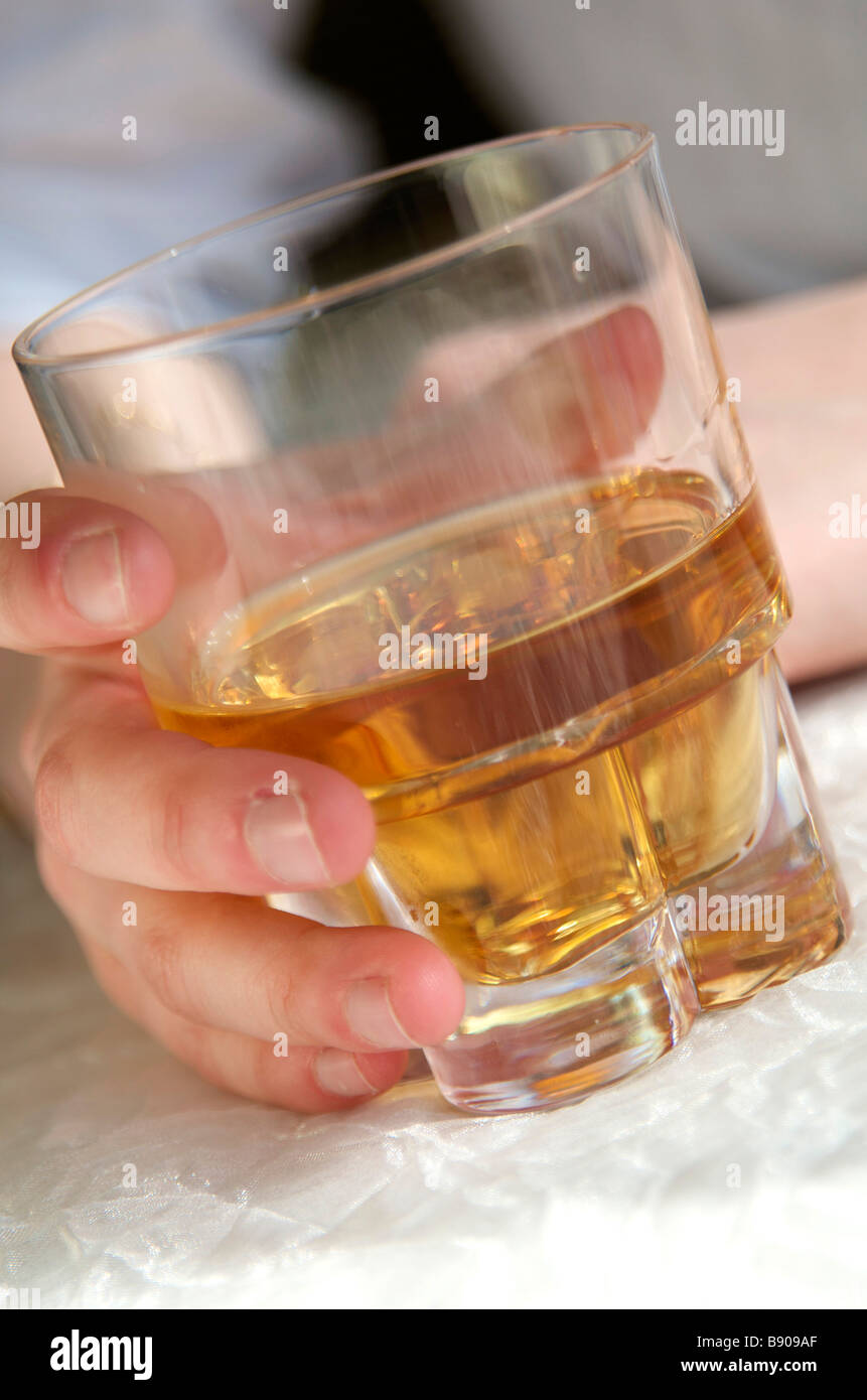 Teenager-Mädchen mit einem Glas Spirituosen / Whisky / Apéro Stockfoto